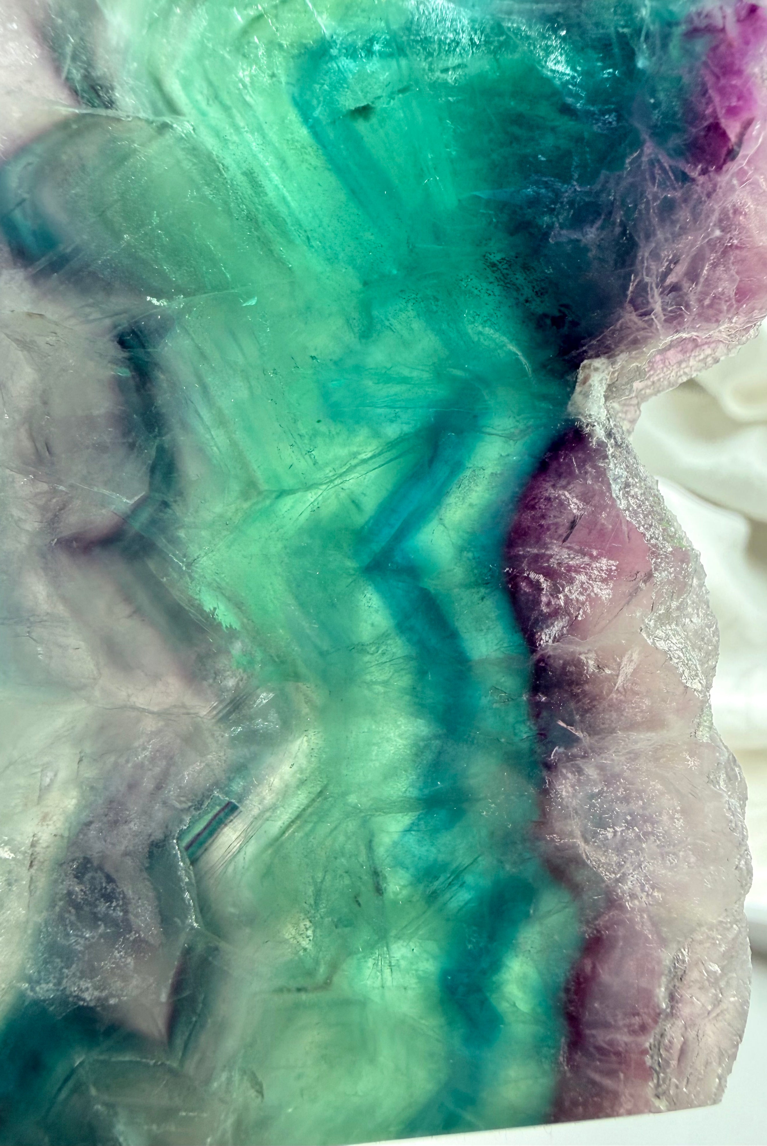 Close-up of natural fluorite slab showing layered color zoning and polished crystal surface