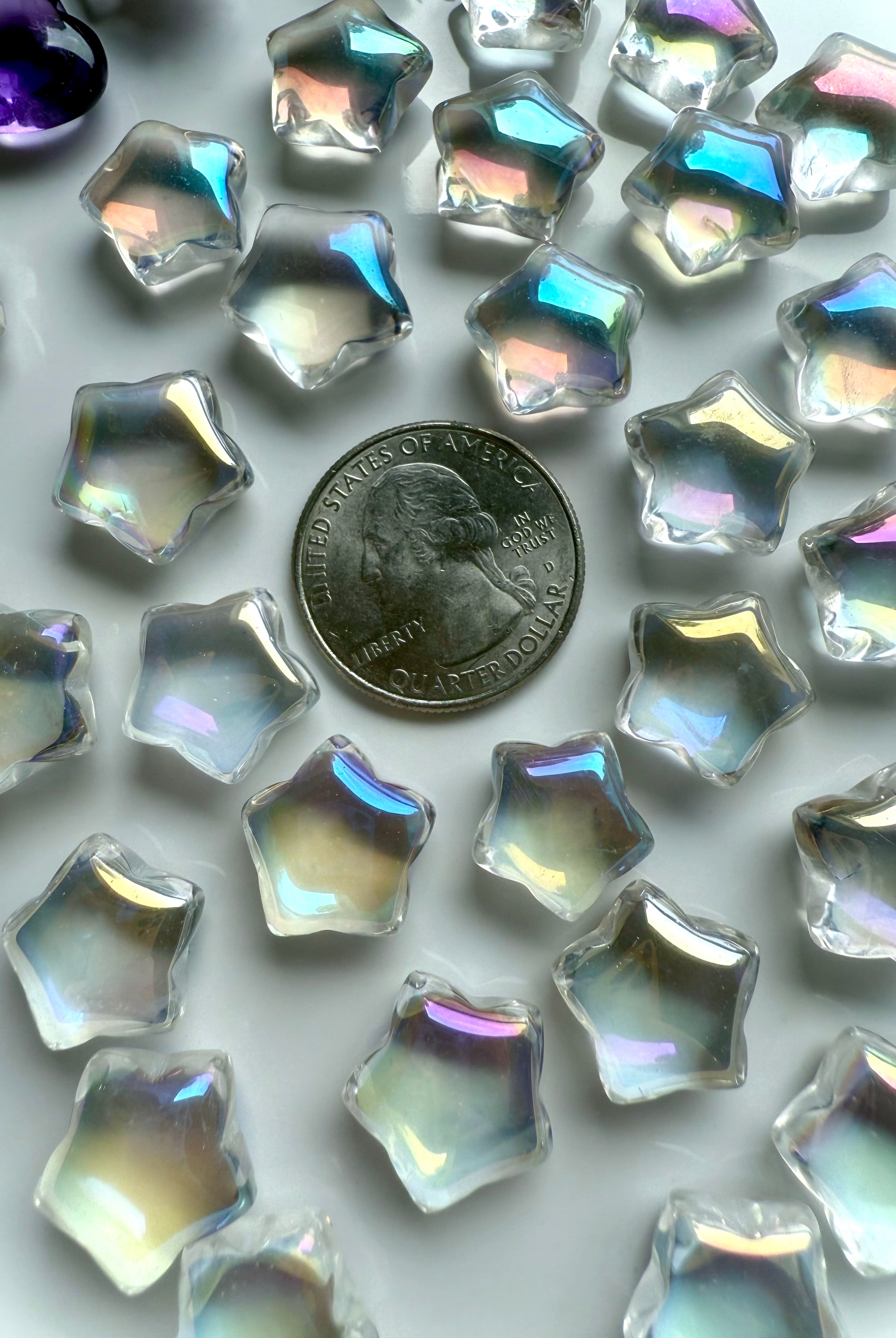 Mini aura quartz stars shown beside quarter coin for size reference — opalescent rainbow crystals for grids, gifts, and altar décor