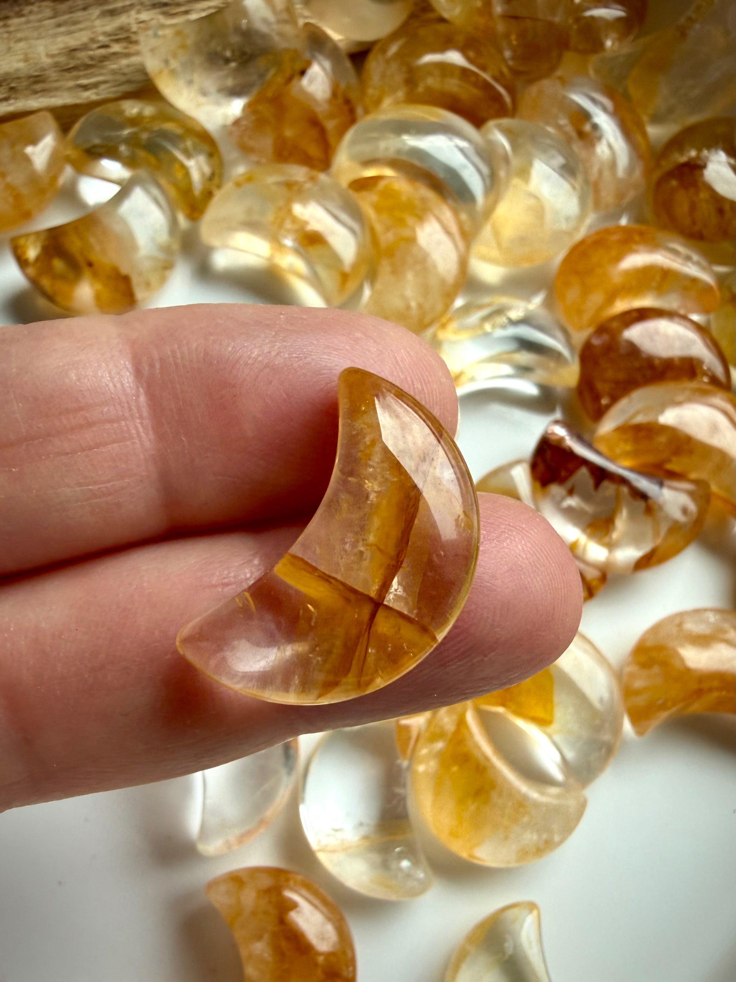 Close up of a polished Golden Healer Quartz crescent moon crystal held in hand showing size & golden details