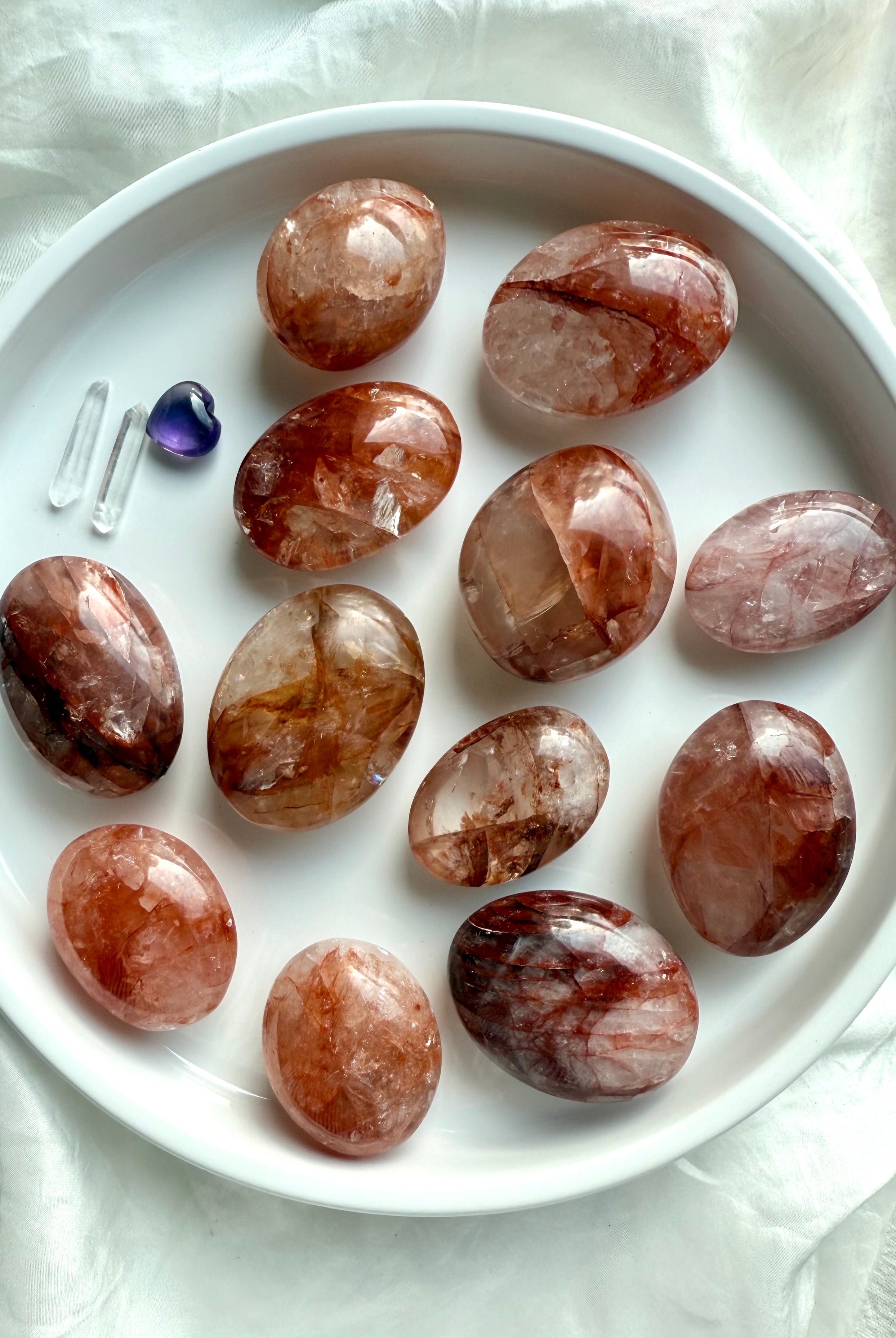 Group of Fire Quartz palm stones with natural variations in hematite inclusions and quartz clarity