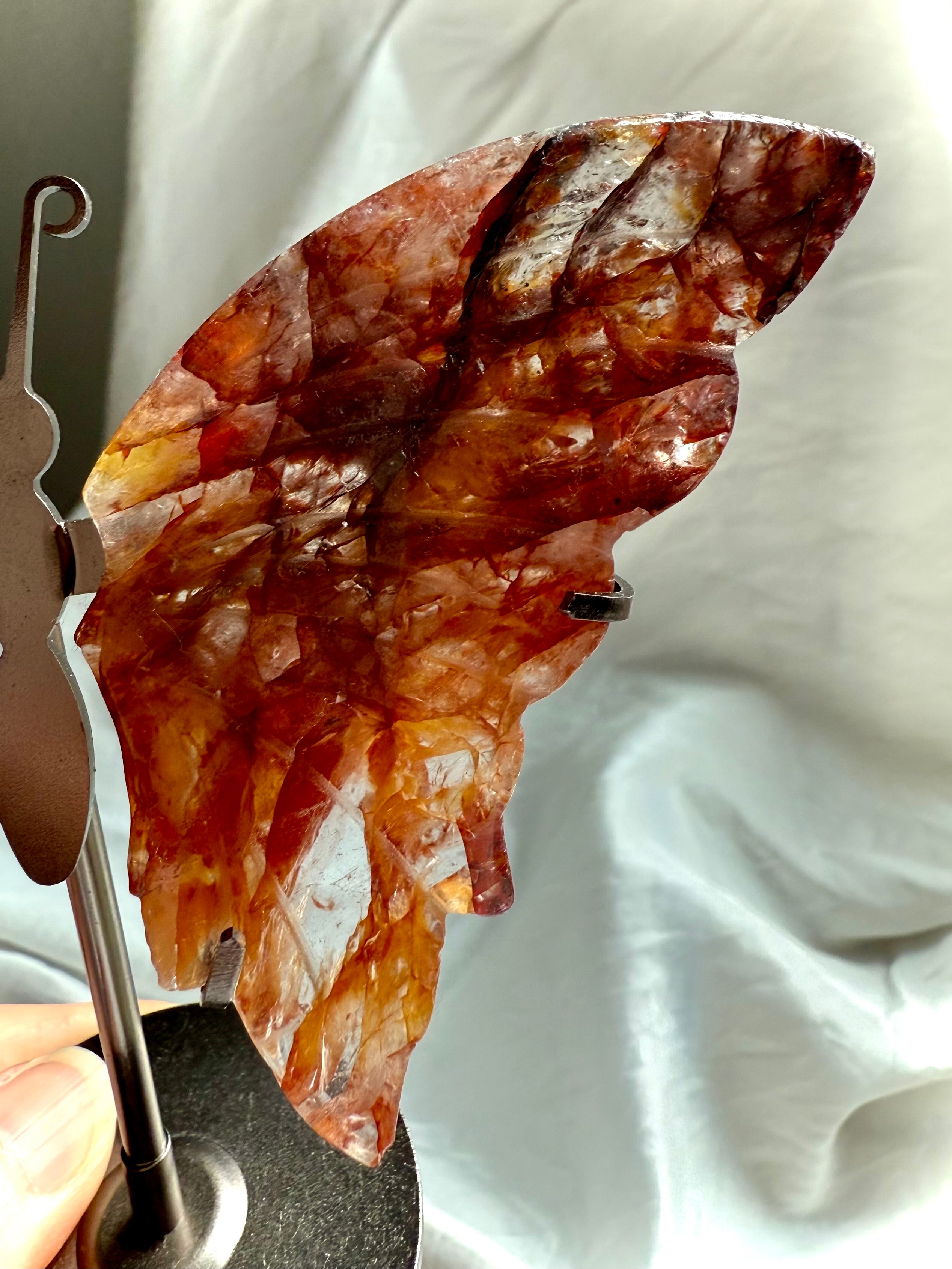 Close-up of Fire Quartz wing carving, displaying layered red, amber, and golden healer quartz textures.