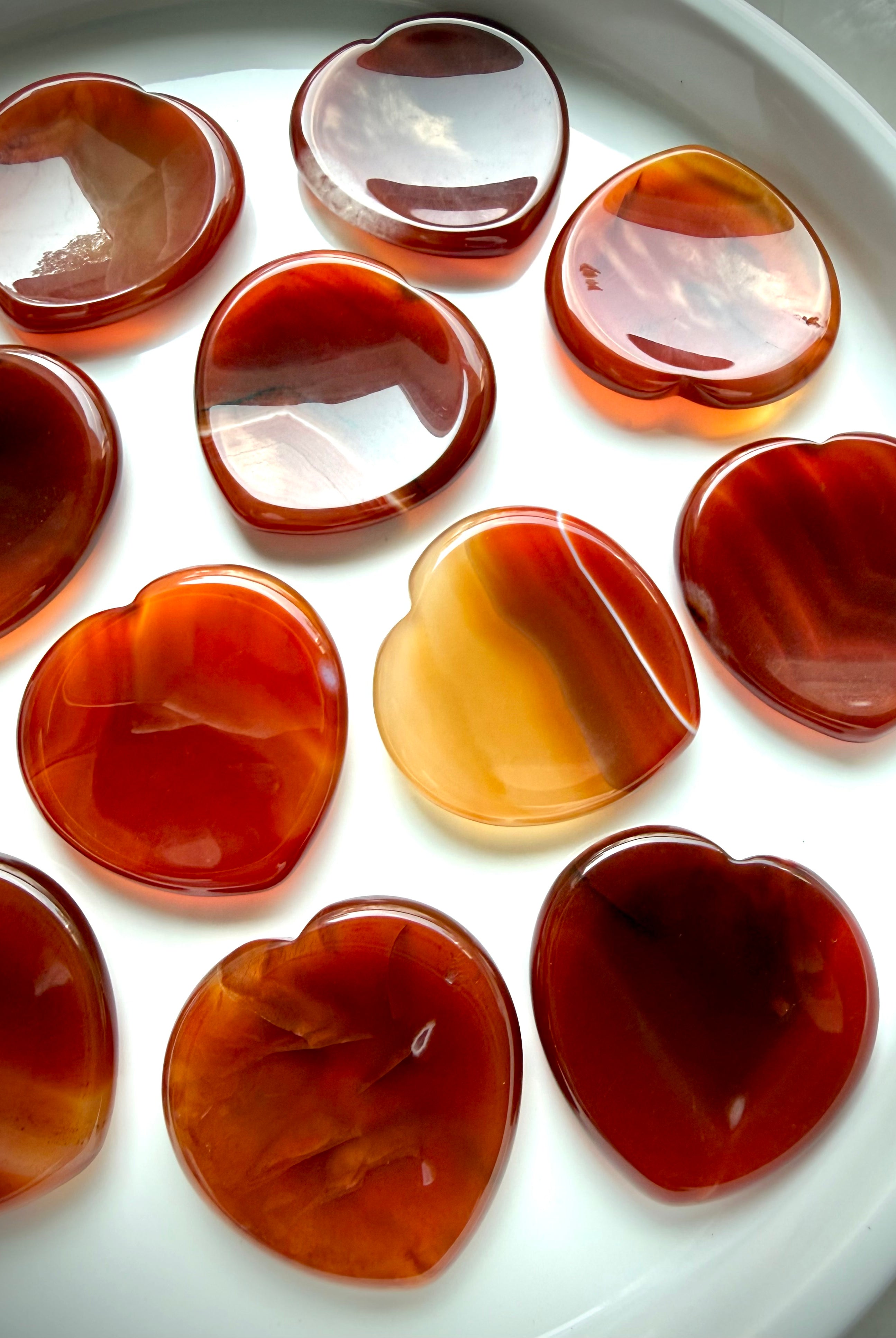 Carnelian heart worry stones with translucent red-orange tones and natural banding for confidence and Sacral Chakra healing