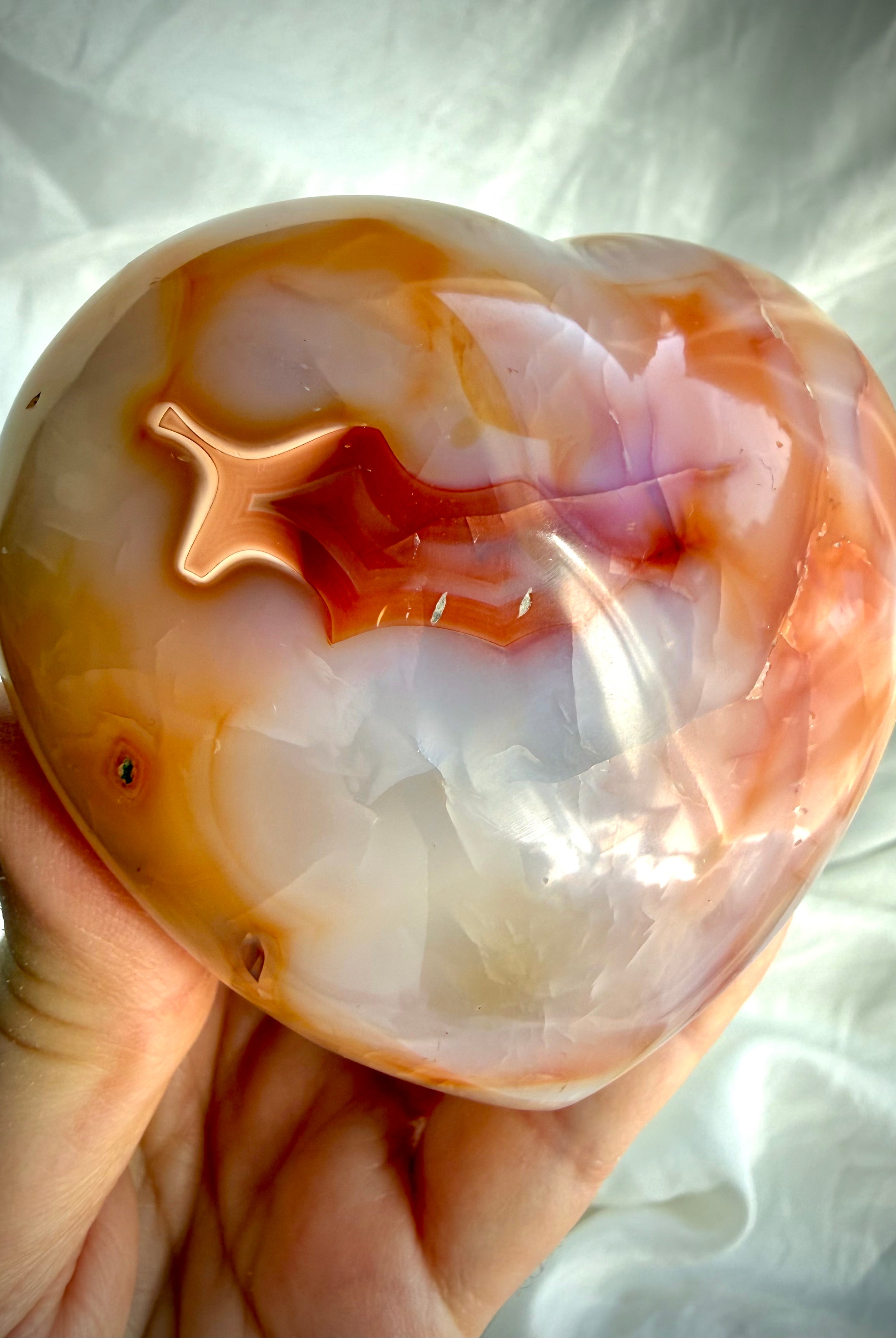 Carnelian heart crystal displaying rich sunset orange banding and natural heart-shaped patterns in polished finish