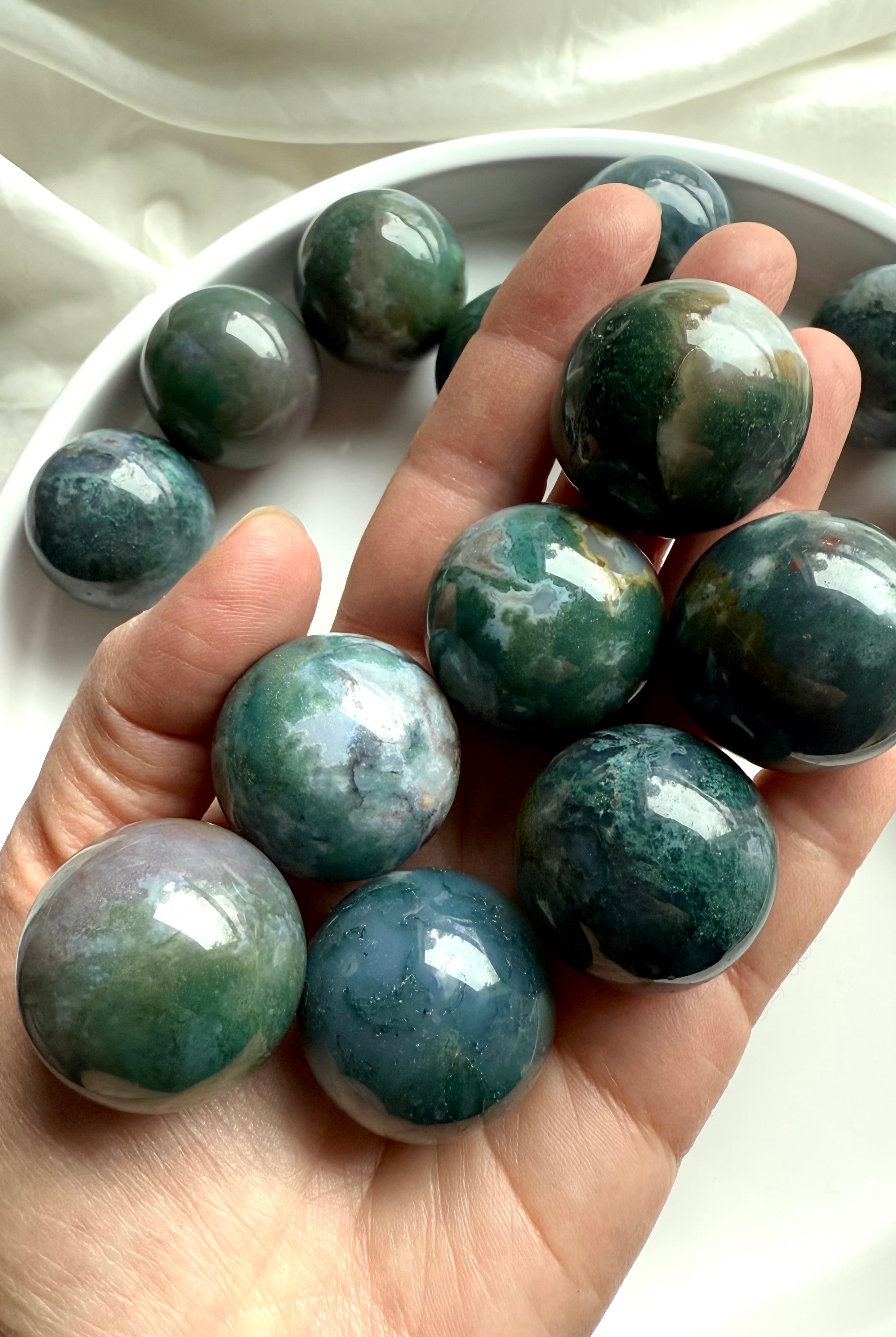 Colorful moss agate mini spheres shown on my hand