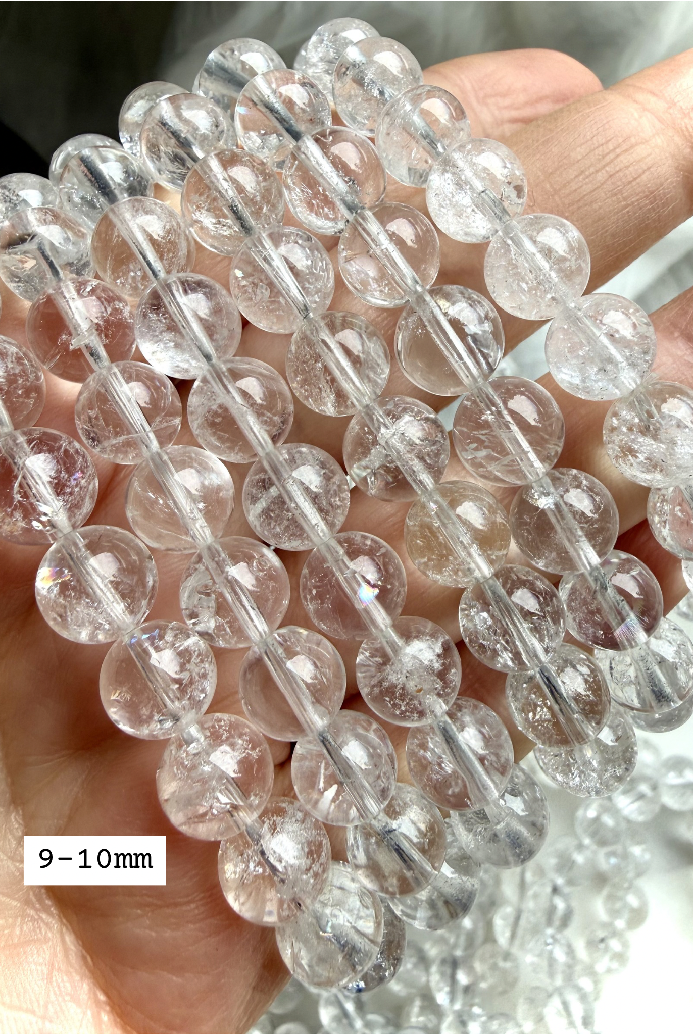 Polished Rainbow Clear Quartz crystal bracelets showing 9-10mm transparent gemstone beads in natural sunlight