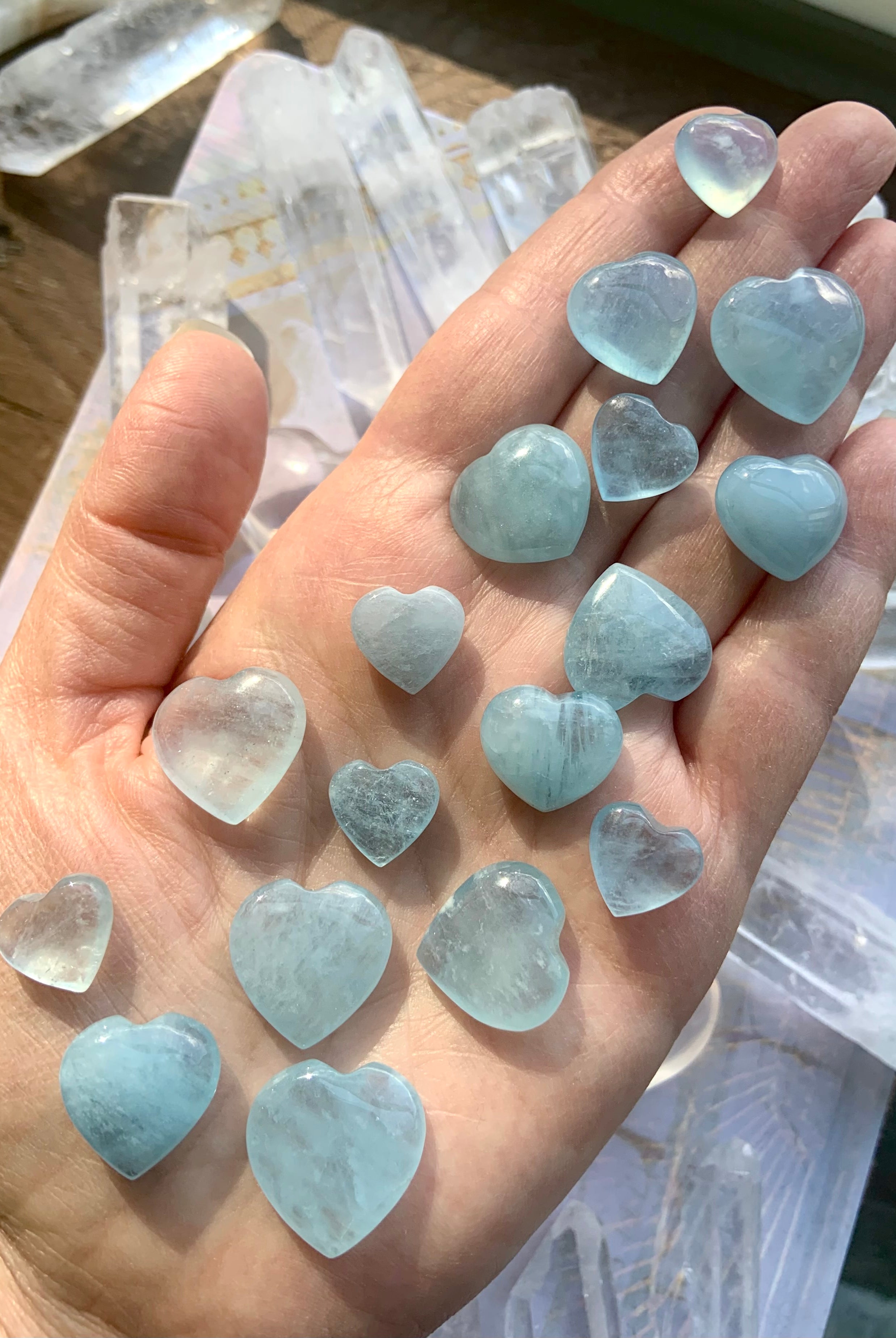Closeup of Aquamarine hearts on a hand — peaceful mini heart carvings for calming anxiety + supporting authentic self-expression.