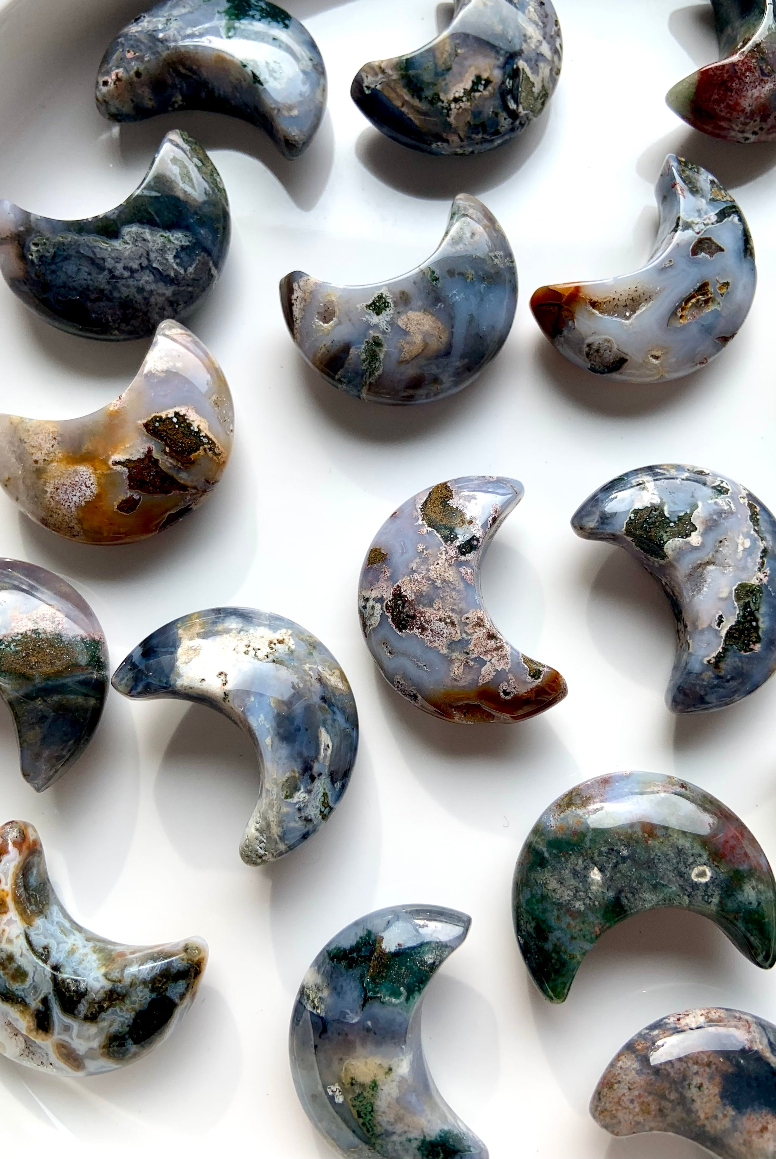 Closeup of Cosmic Ocean Jasper moon carvings with vibrant colors and natural patterns, unique healing crystals for heart chakra support