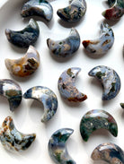 Closeup of Cosmic Ocean Jasper moon carvings with vibrant colors and natural patterns, unique healing crystals for heart chakra support
