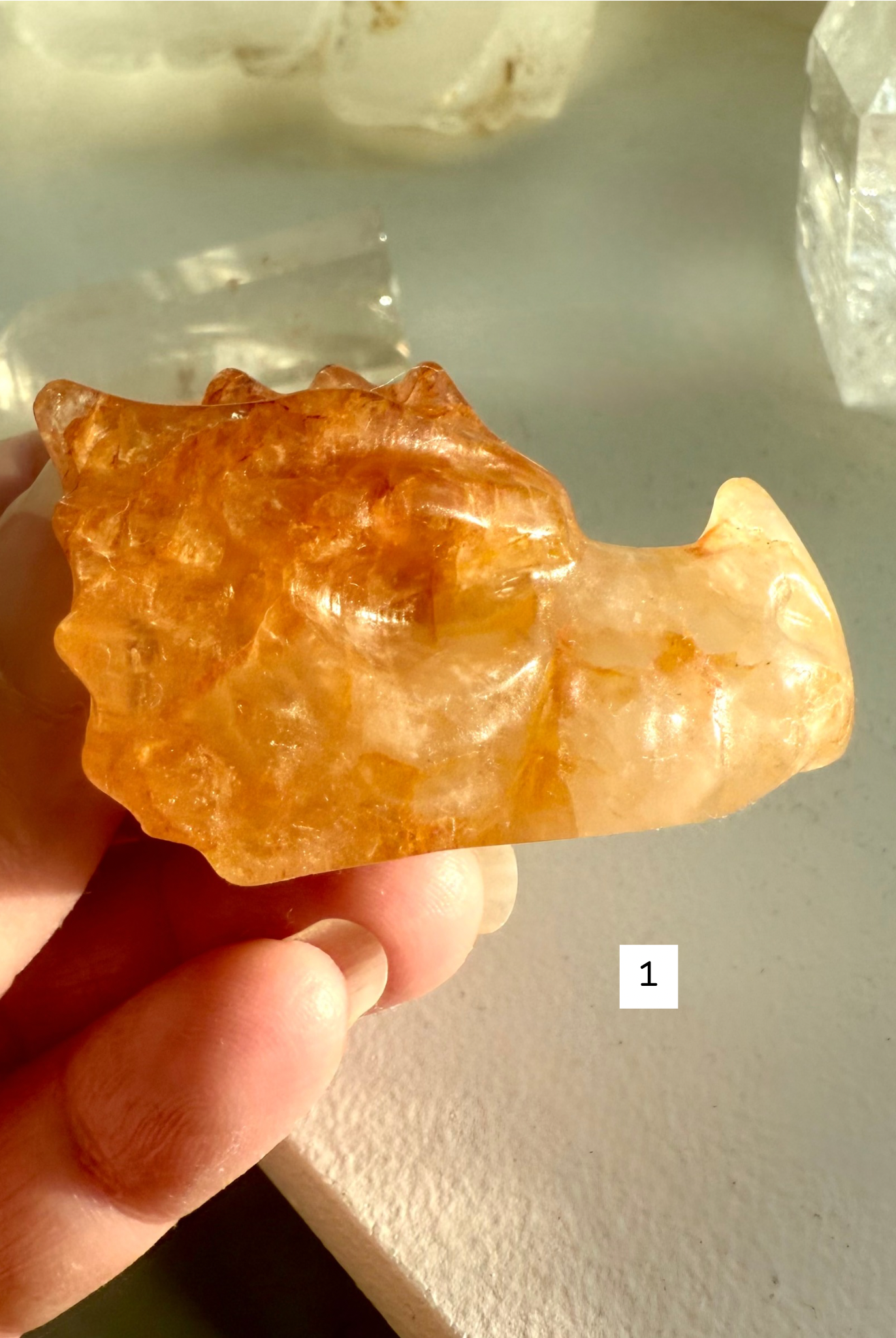 Golden Healer Quartz dragon head carving held in hand — crystal figurine with golden hematite inclusions for chakra healing and energy work.