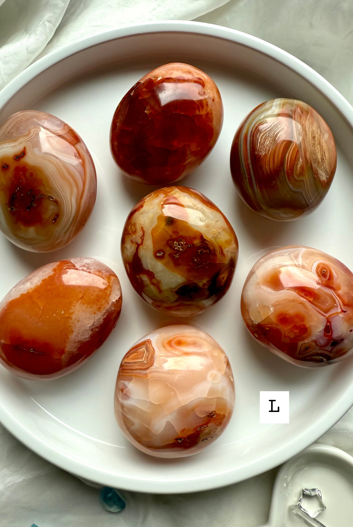Large Carnelian palm stone with layered red-orange banding — powerful crystal for strength, passion + inner fire