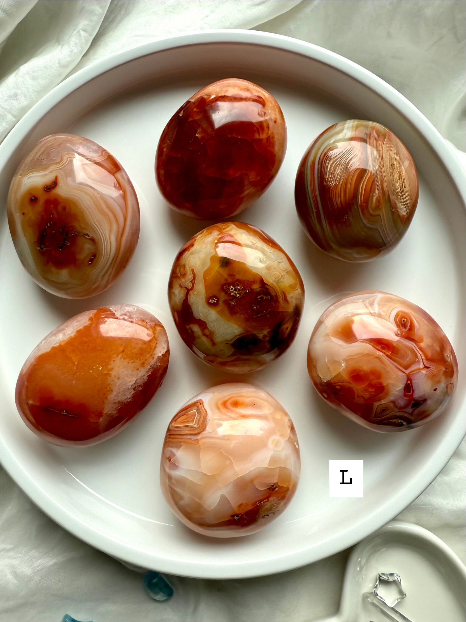 Large Carnelian palm stone with layered red-orange banding — powerful crystal for strength, passion + inner fire