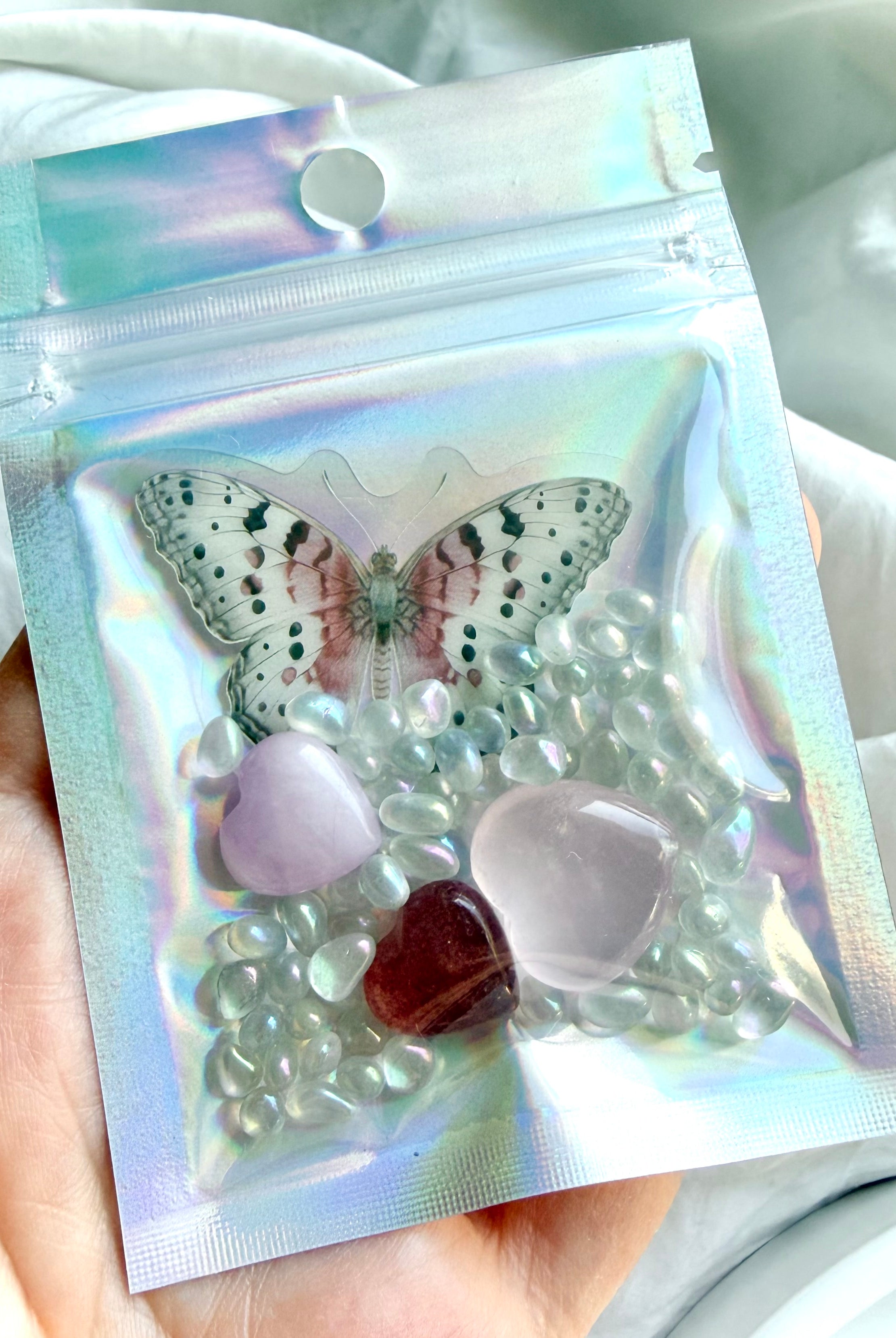 Mini crystal heart trio gift set in iridescent pouch with butterfly sticker, rose quartz, strawberry quartz, kunzite, and aura crystal confetti