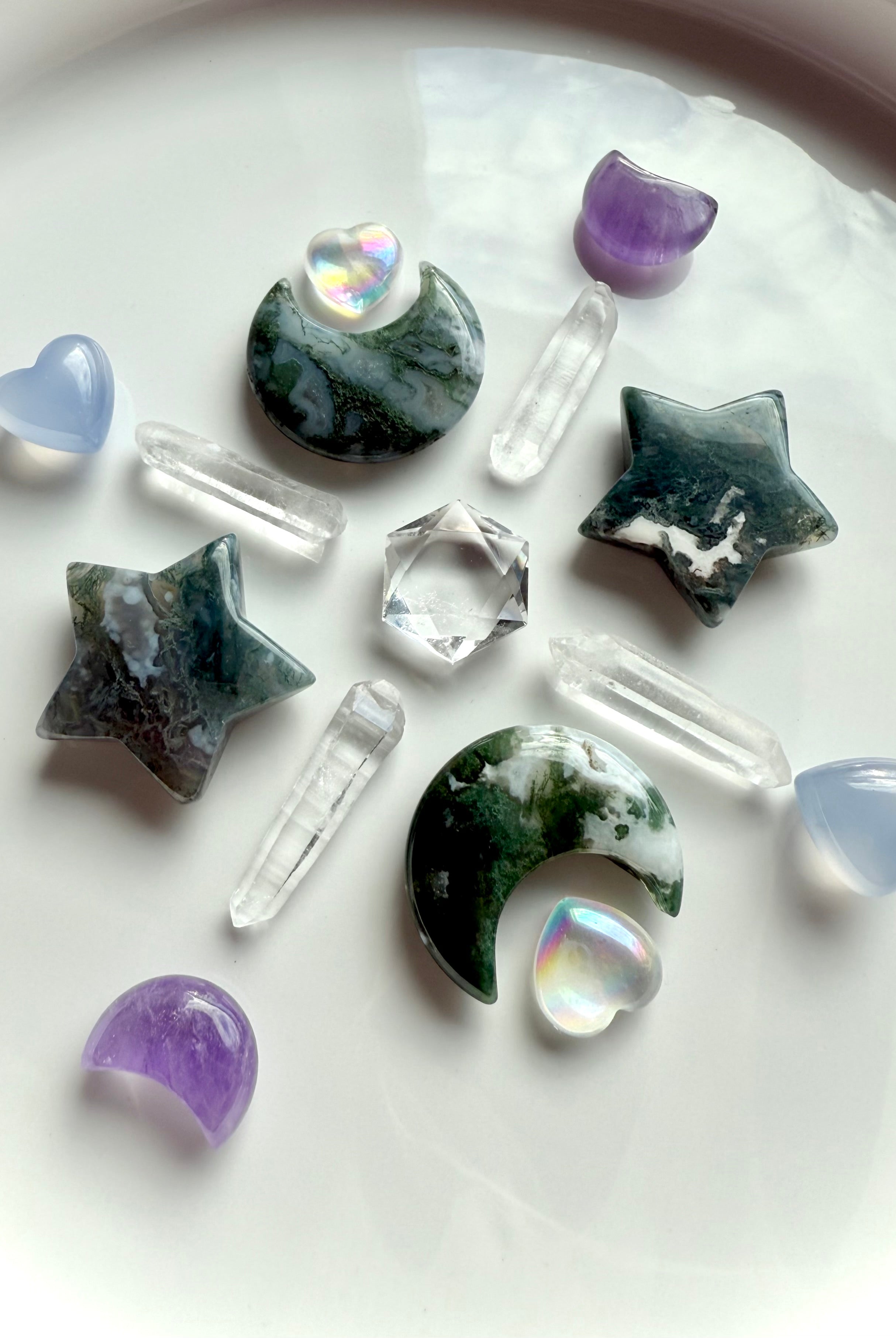 Moss Agate moons and stars arranged with aura quartz, amethyst, and clear quartz points — earthy heart chakra carving for grounding rituals and Gaia energy.
