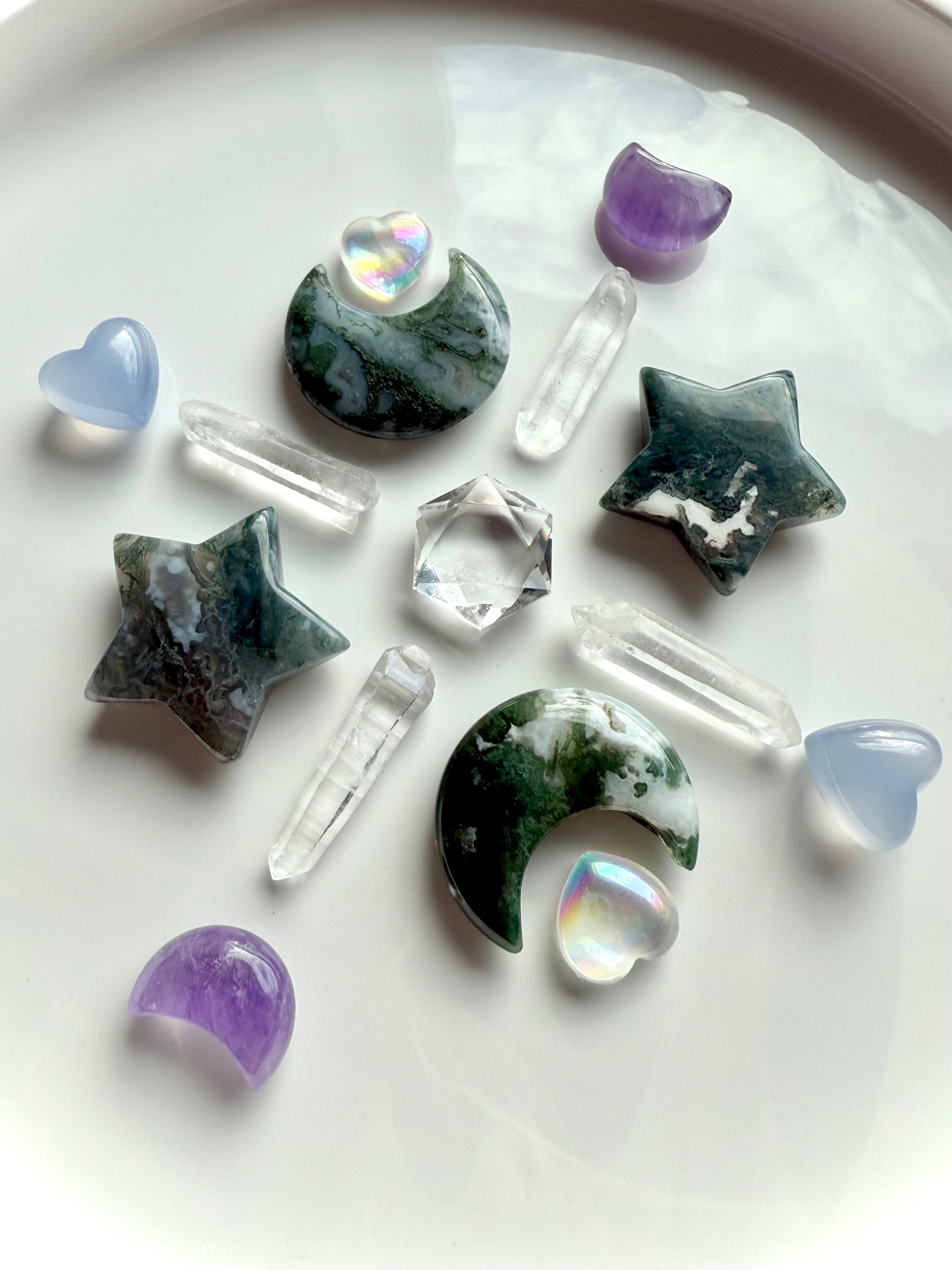 Moss Agate moons and stars arranged with aura quartz, amethyst, and clear quartz points — earthy heart chakra carving for grounding rituals and Gaia energy.