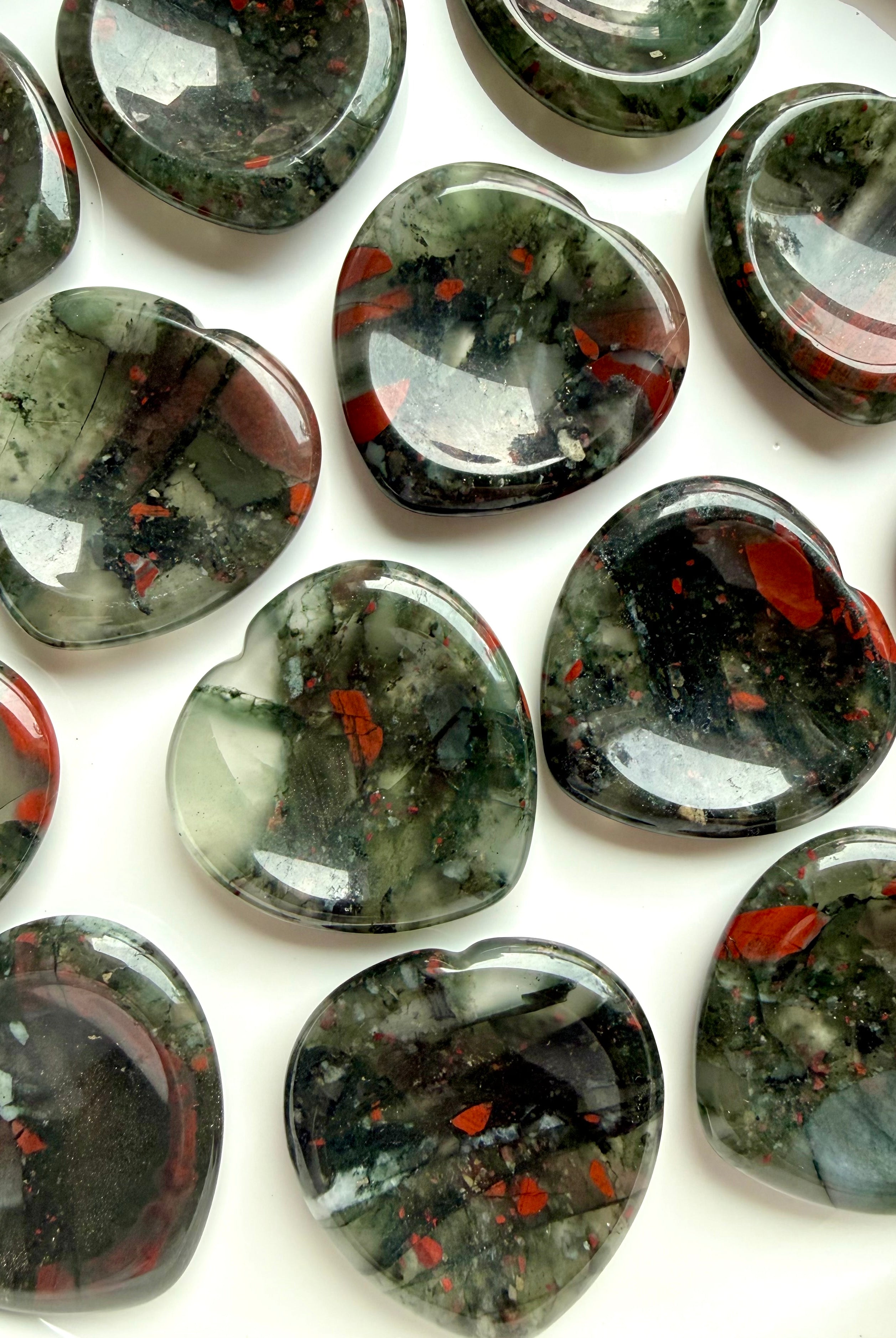 top view of bloodstone hearts in bowl with varied red and green patterning, worry stones for strength grounding and resilience