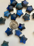 Close-up of deep blue Labradorite crystal stars with a dime for scale — mini star carvings for Third Eye chakra, intuition & energetic shielding.