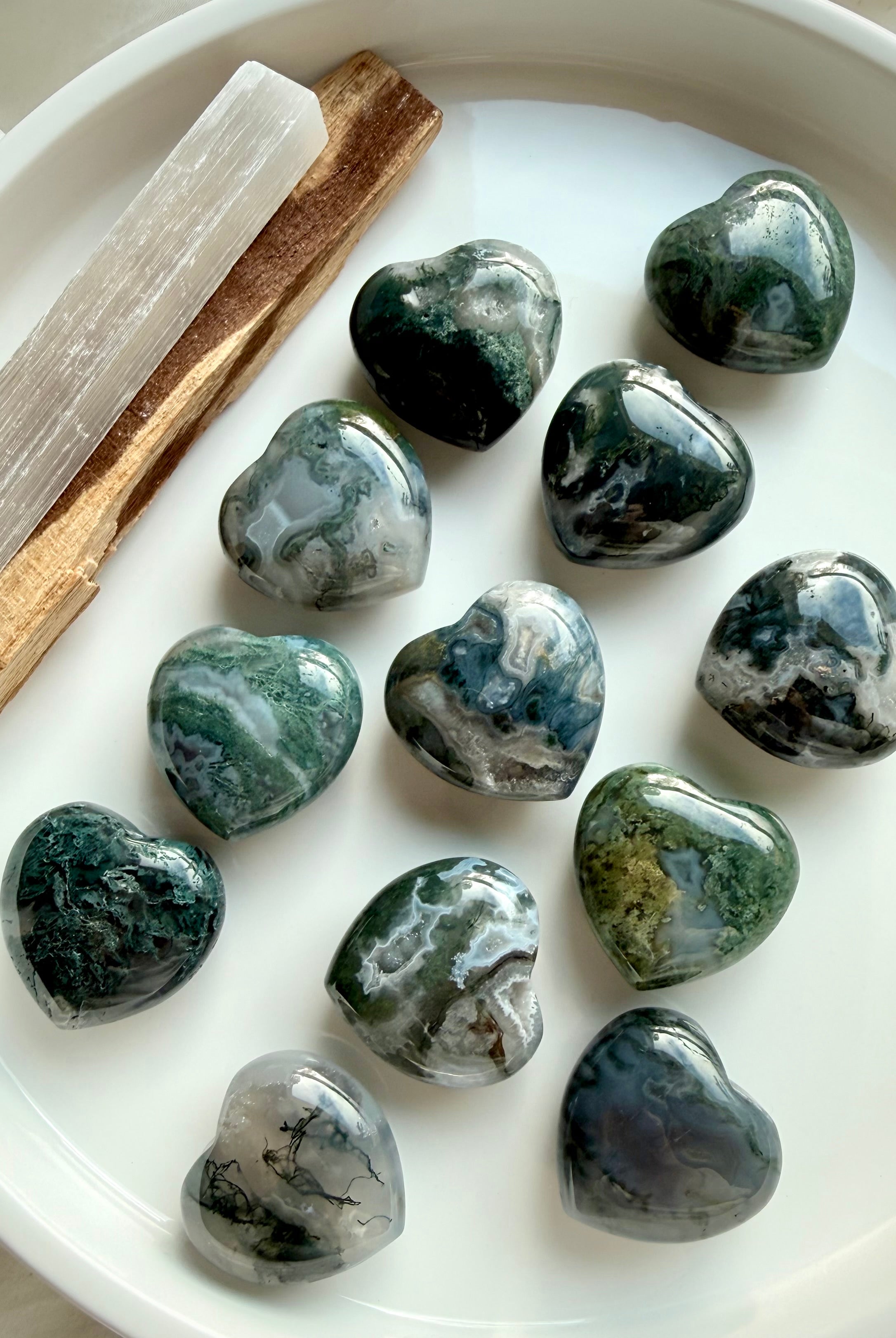 Polished Moss Agate hearts with earthy green inclusions, styled with selenite and palo santo for crystal healing