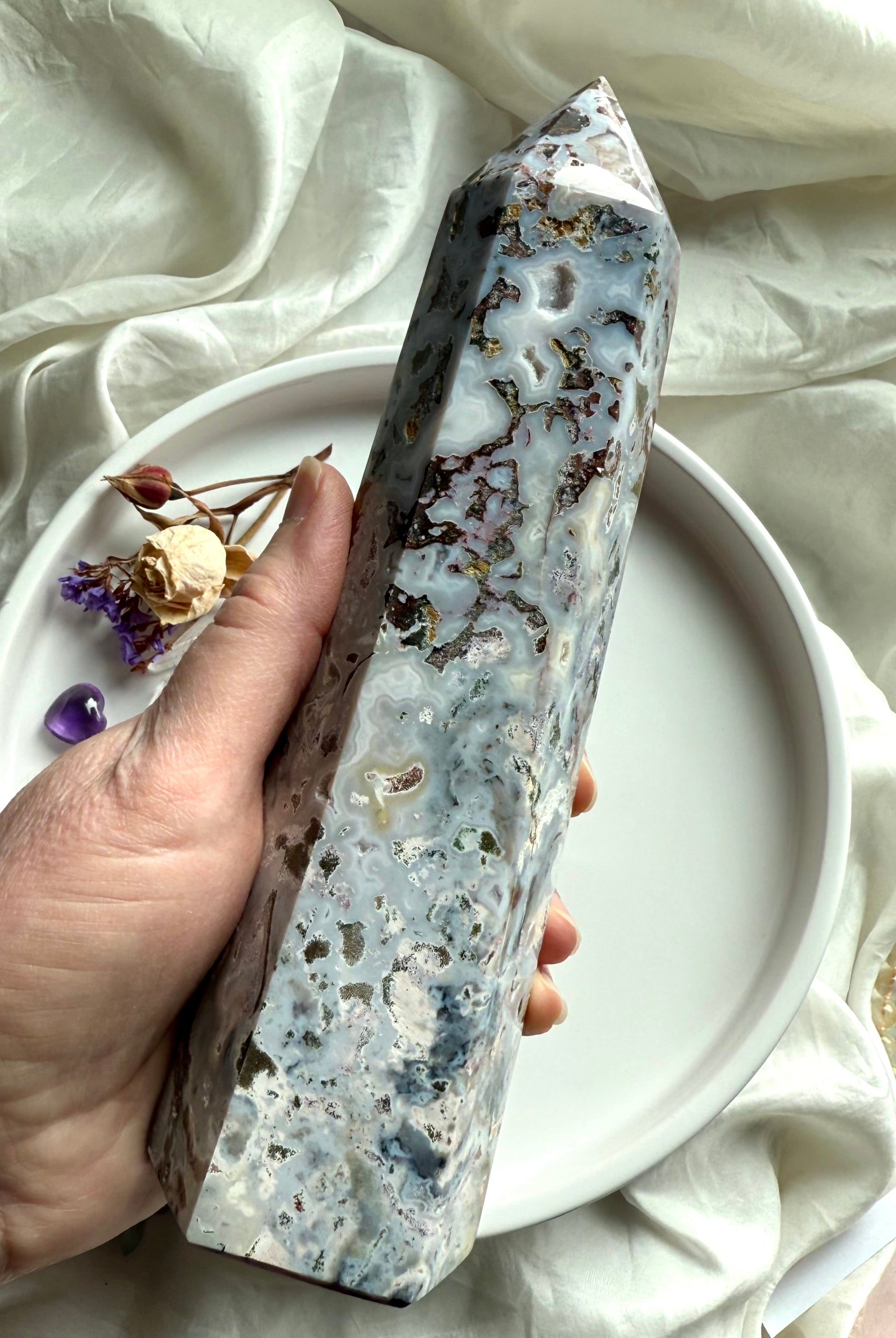 Hand-held Cosmic Ocean Jasper crystal point with flowing oceanic banding, mossy mineral inclusions, and polished faces