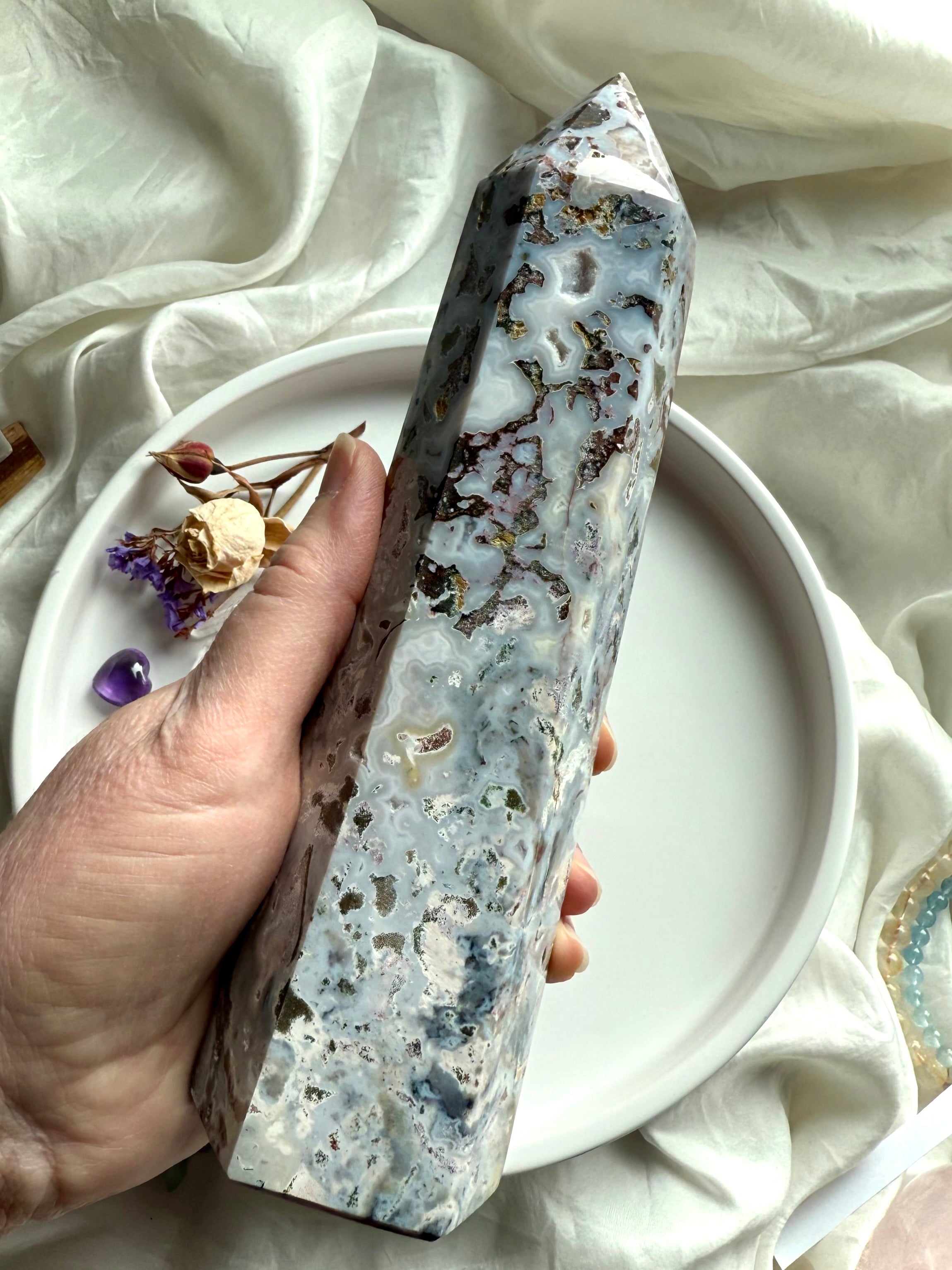 Hand-held Cosmic Ocean Jasper crystal point with flowing oceanic banding, mossy mineral inclusions, and polished faces