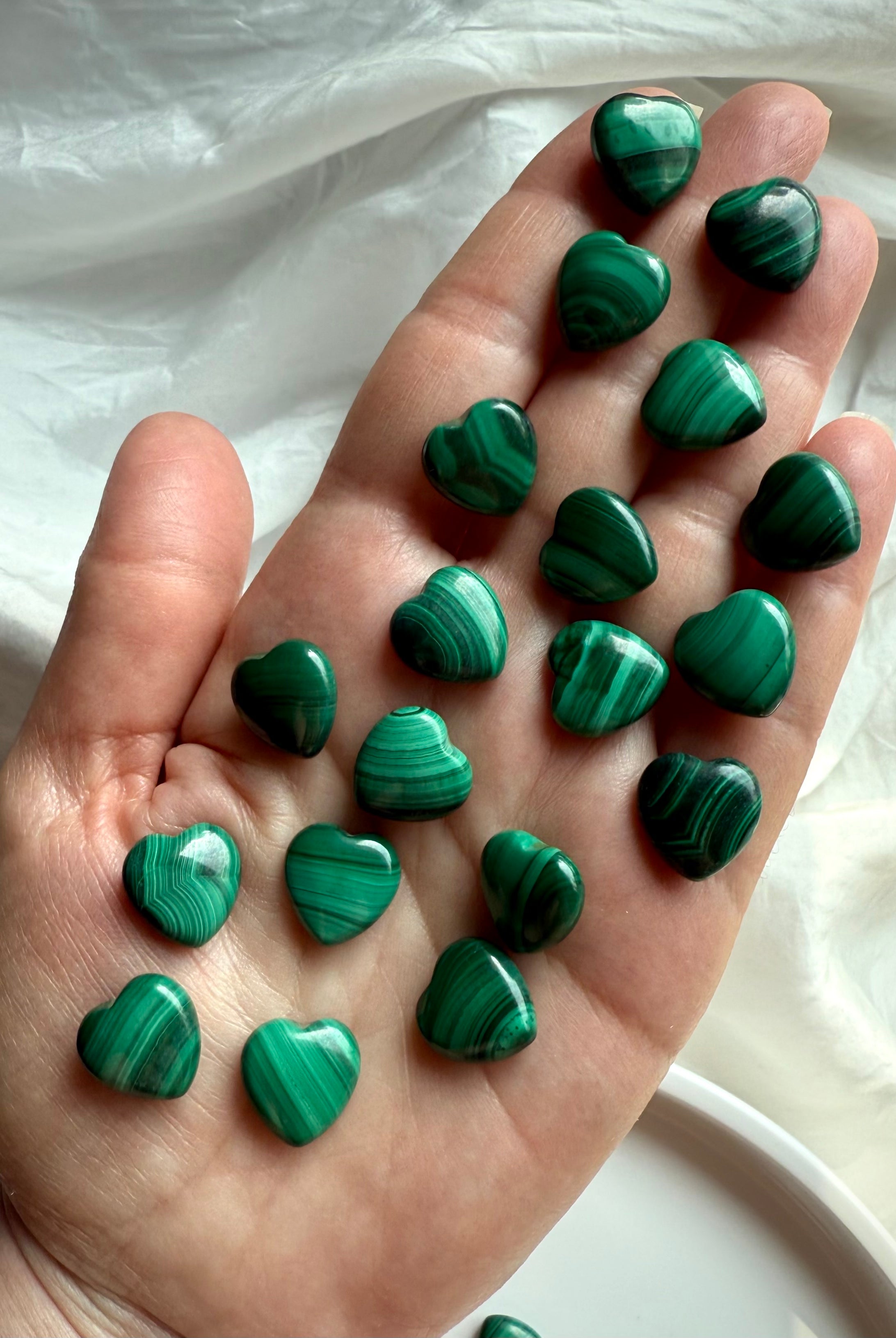 High-quality Mini Malachite crystal hearts displayed in hand showing natural green banding and swirling patterns