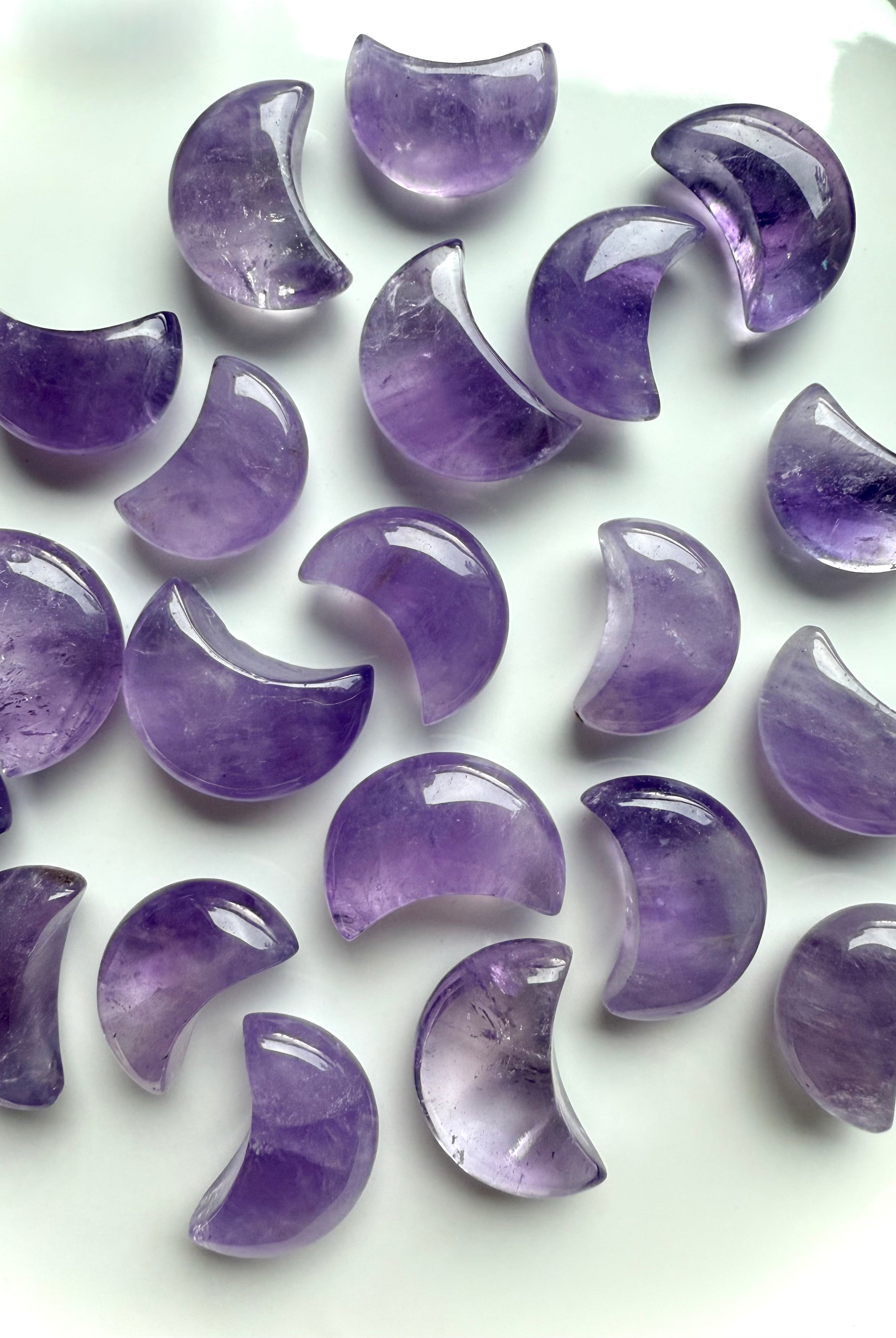 Polished amethyst crescent moons showing natural lavender to deep purple color variation