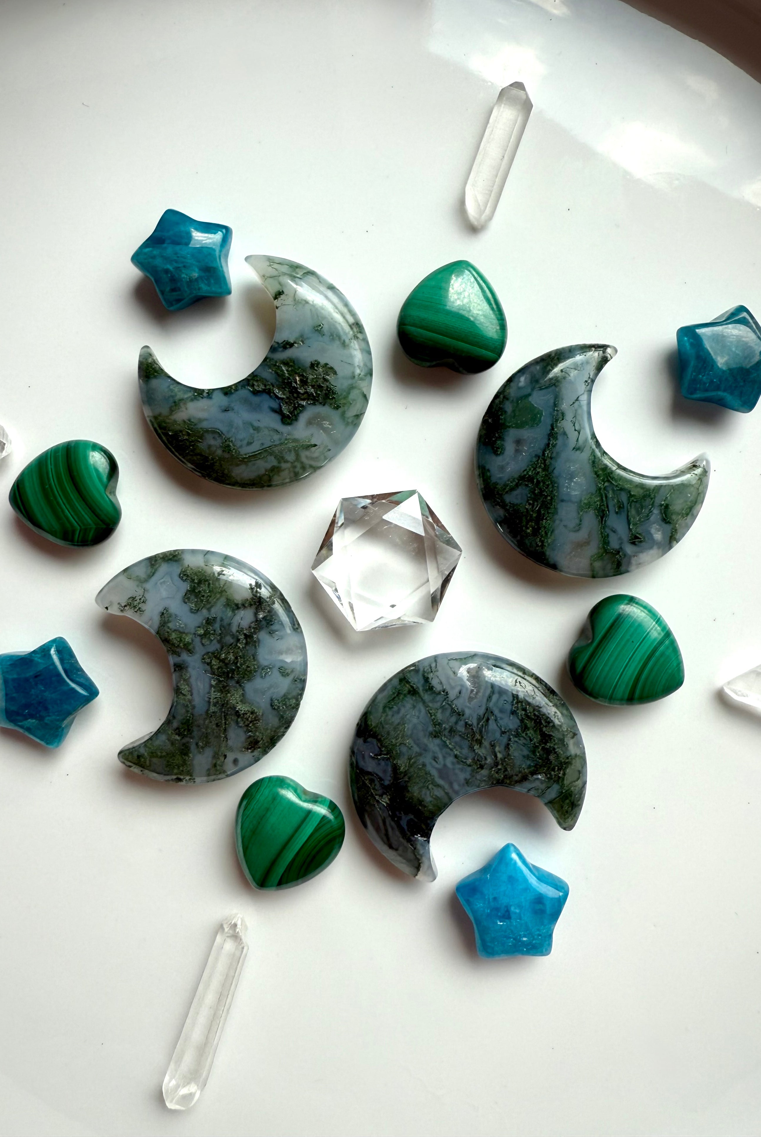 Nature-inspired crystal grid with Moss Agate moons, Apatite stars, Malachite hearts, and Quartz points around a Clear Quartz hexagon centerpiece.