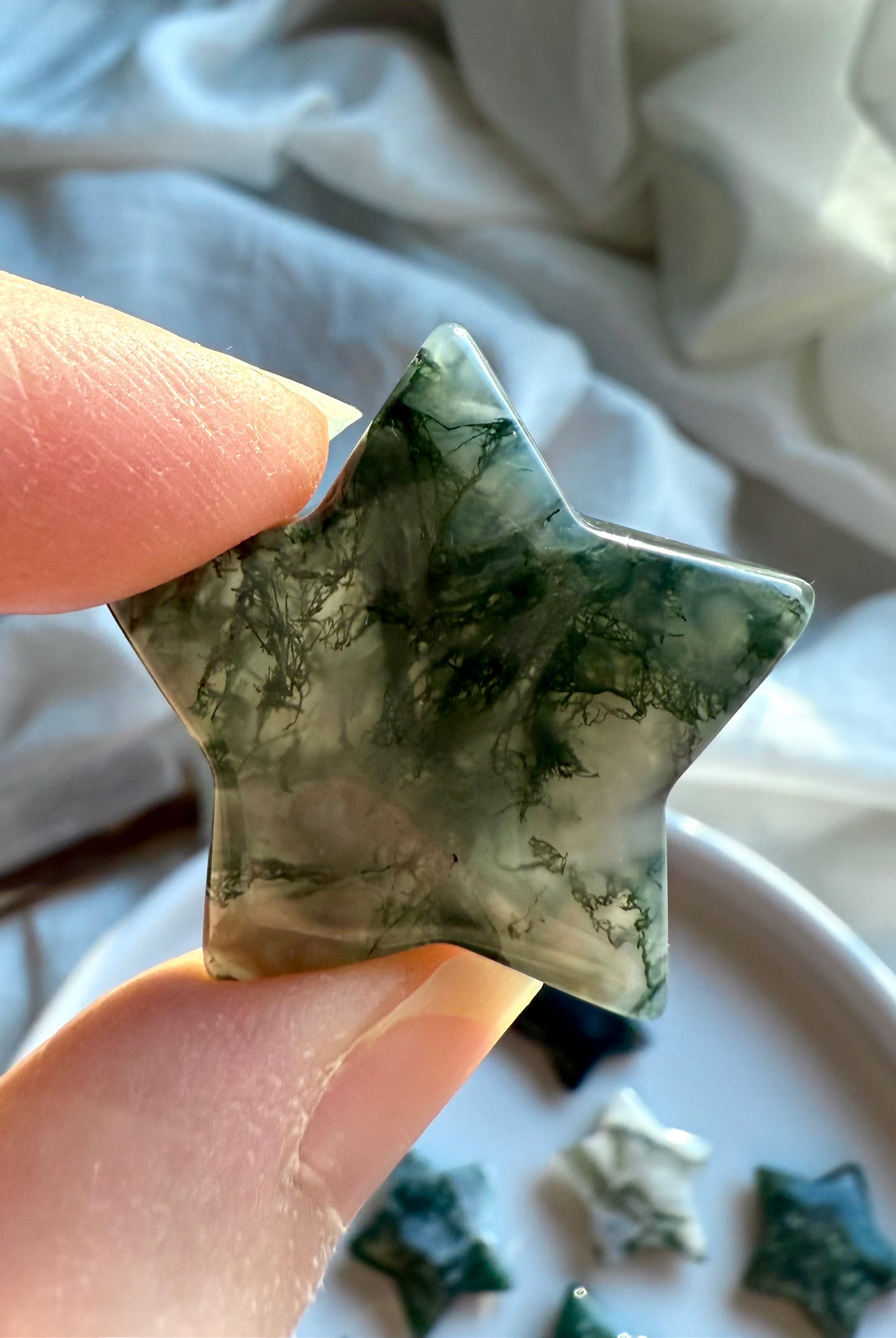 close-up moss agate star showing detailed green dendritic inclusions and translucent chalcedony for grounding and Gaia connection