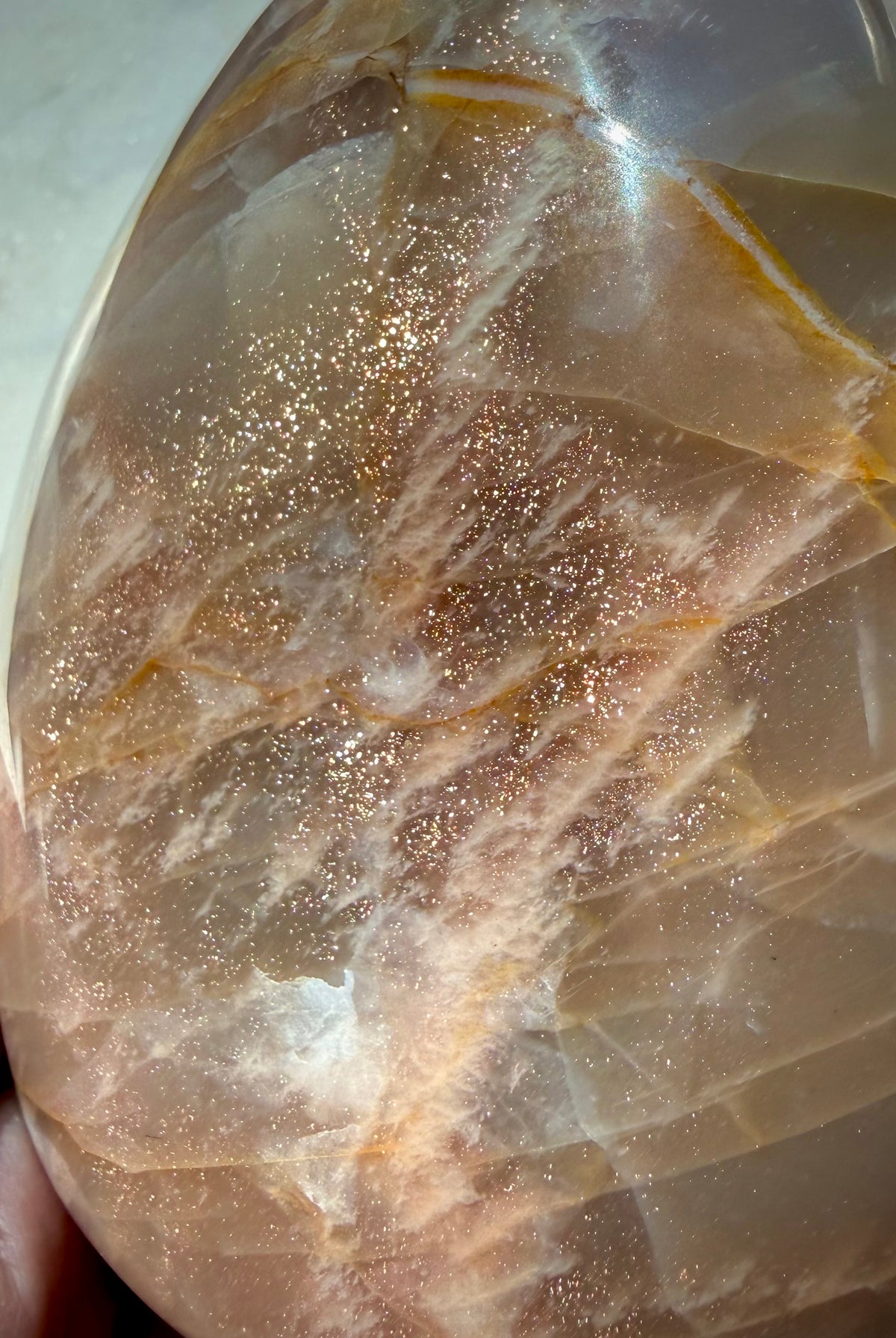 Close-up of Peach Moonstone freeform with sparkling golden Sunstone inclusions and warm orange peach tones