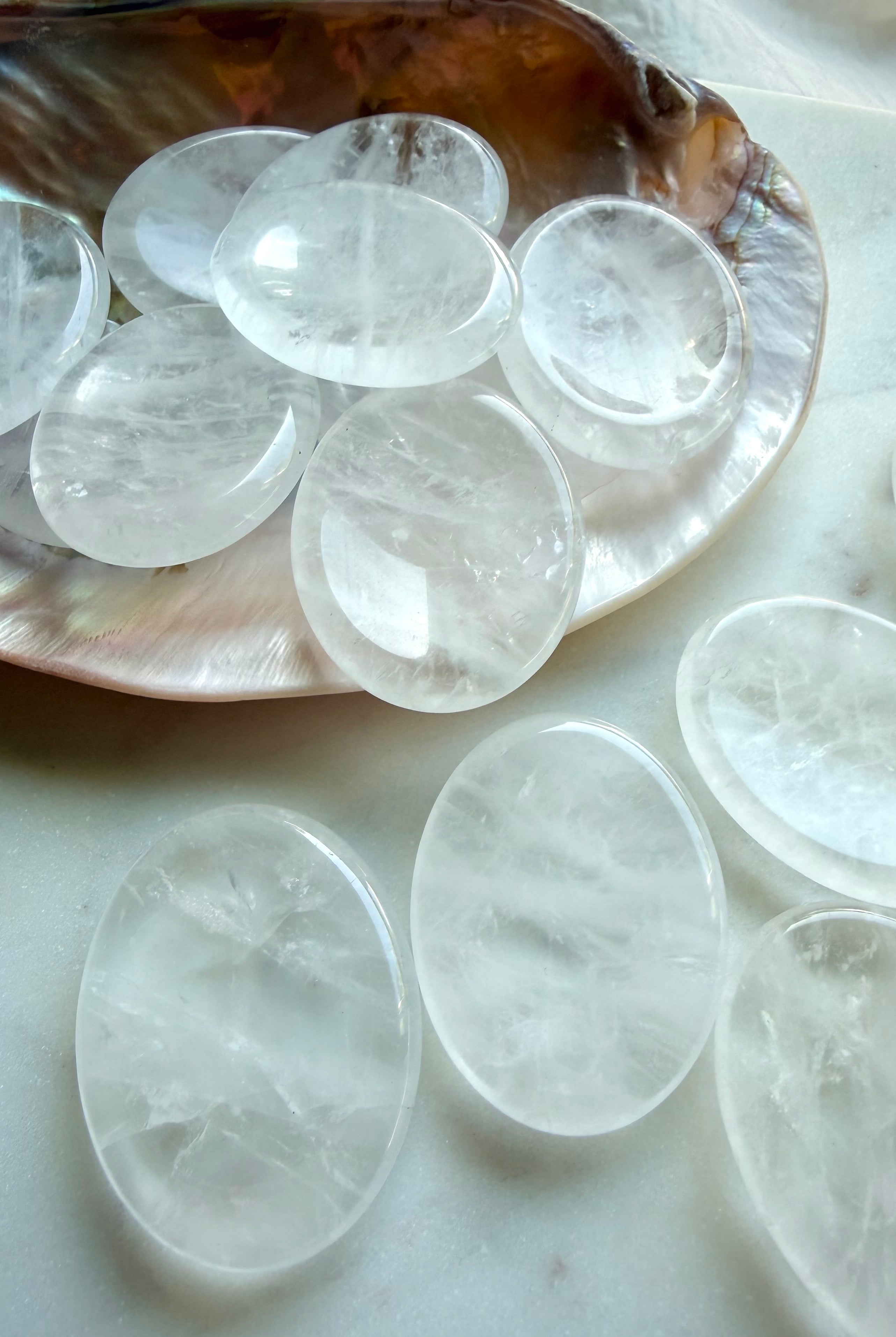 clear quartz worry stones arranged on seashell dish for meditation focus and crystal healing