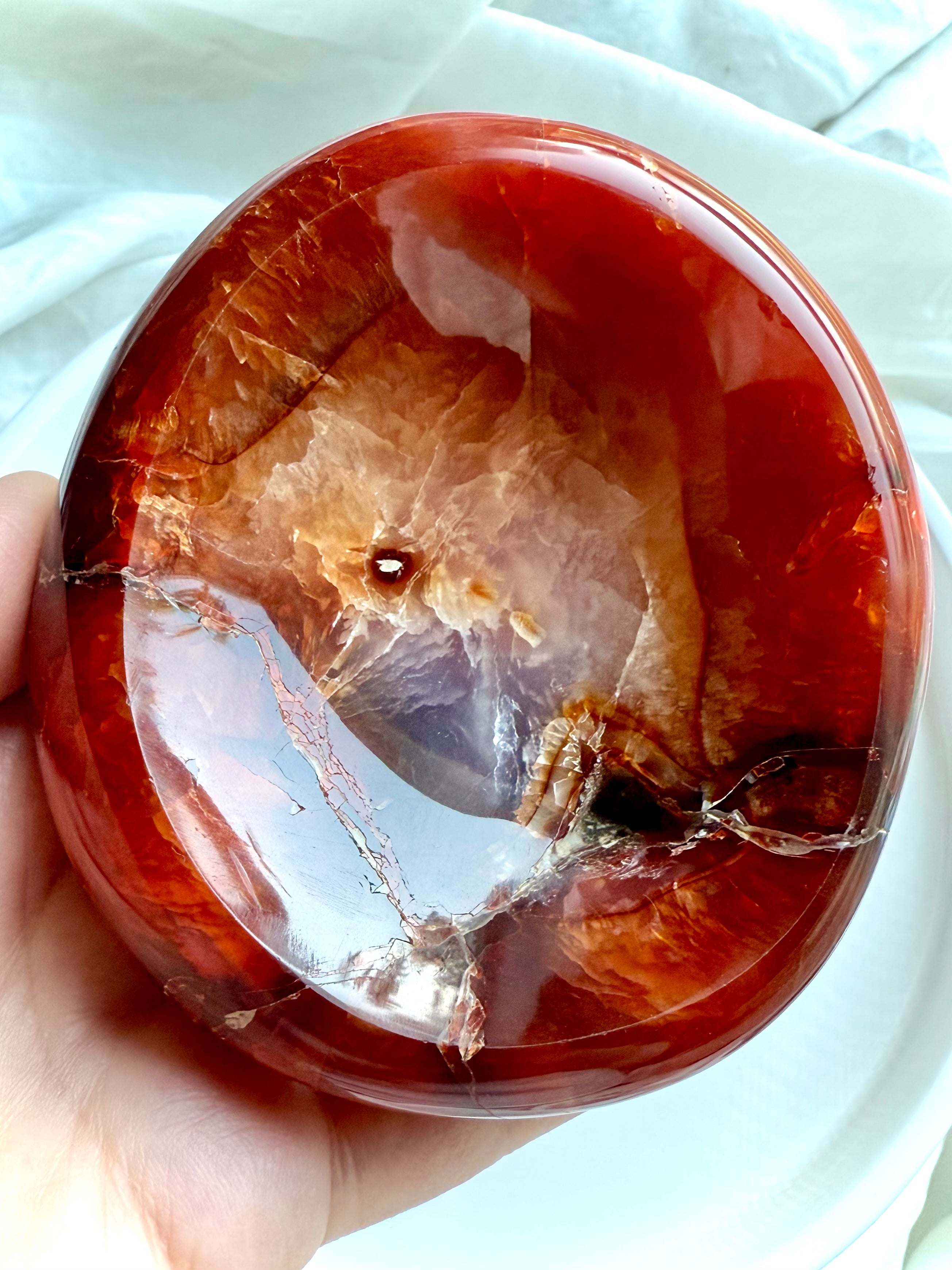 Hand holding natural Carnelian bowl with vivid patterning – carved crystal dish for passion and creativity