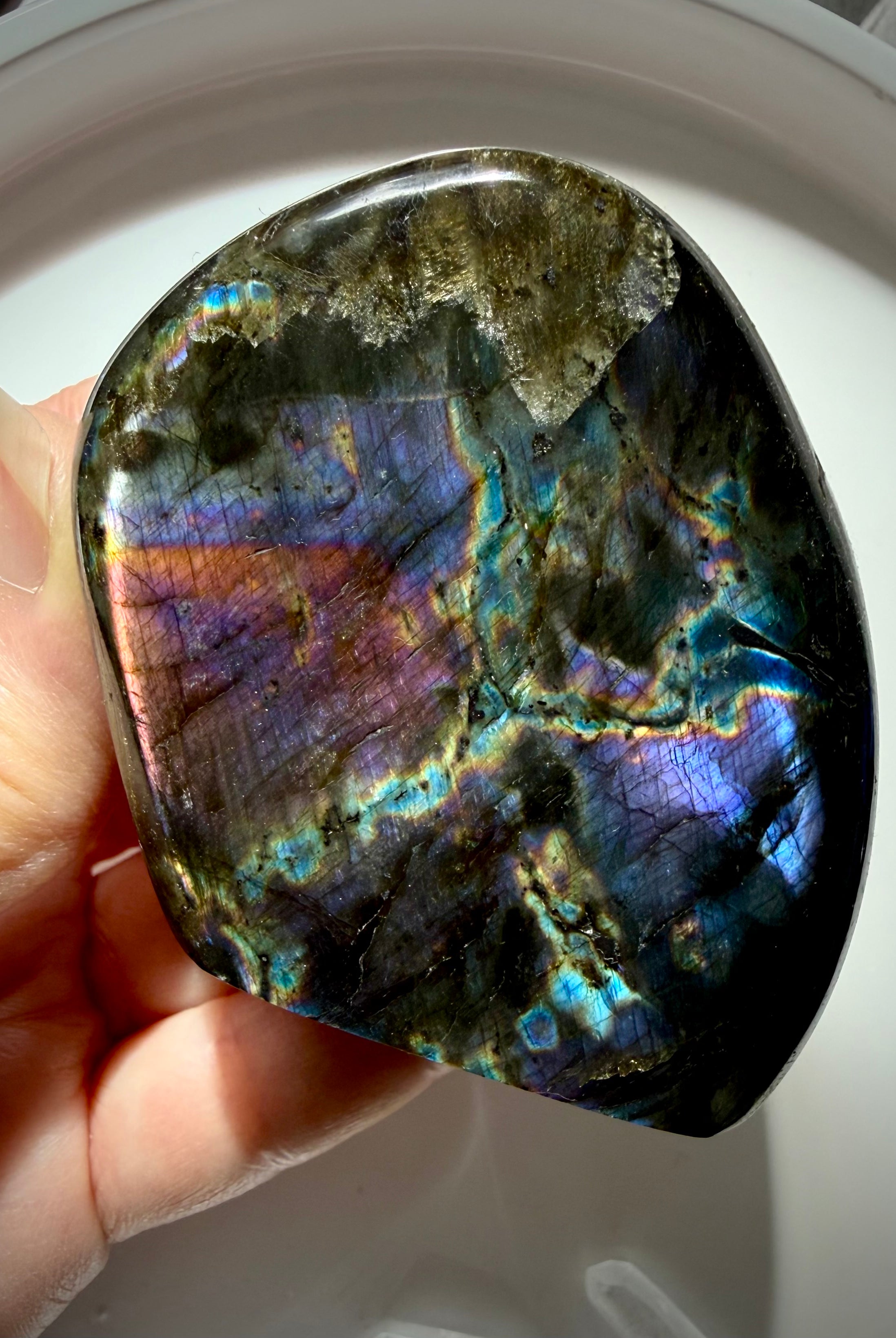 Rainbow Labradorite freeform held in hand with colorful flash for intuition, protection and transformation