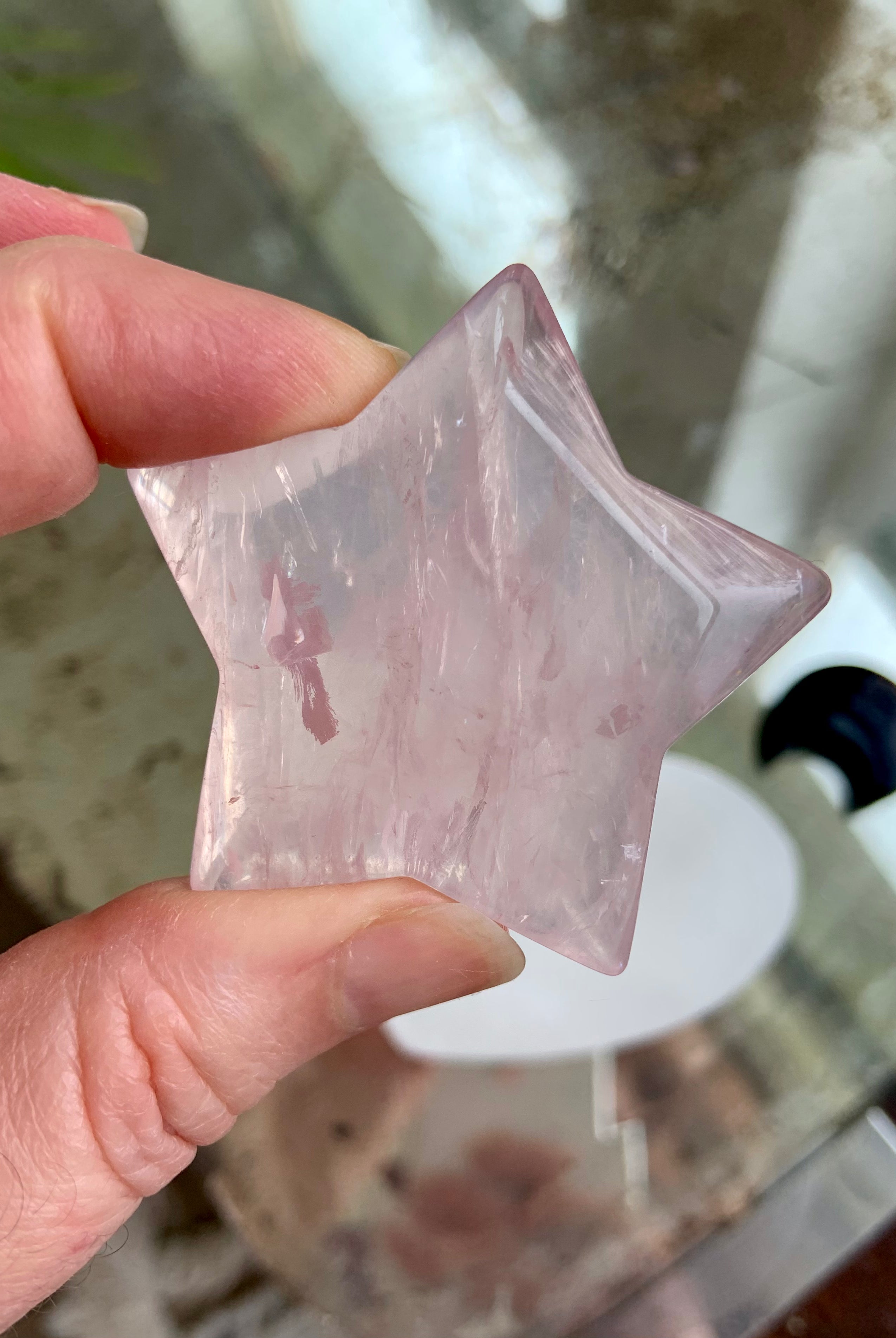 Rose Quartz crystal star close up showing natural color variation, polished carving, and clarity — Mozambique Rose Quartz star for heart chakra healing.