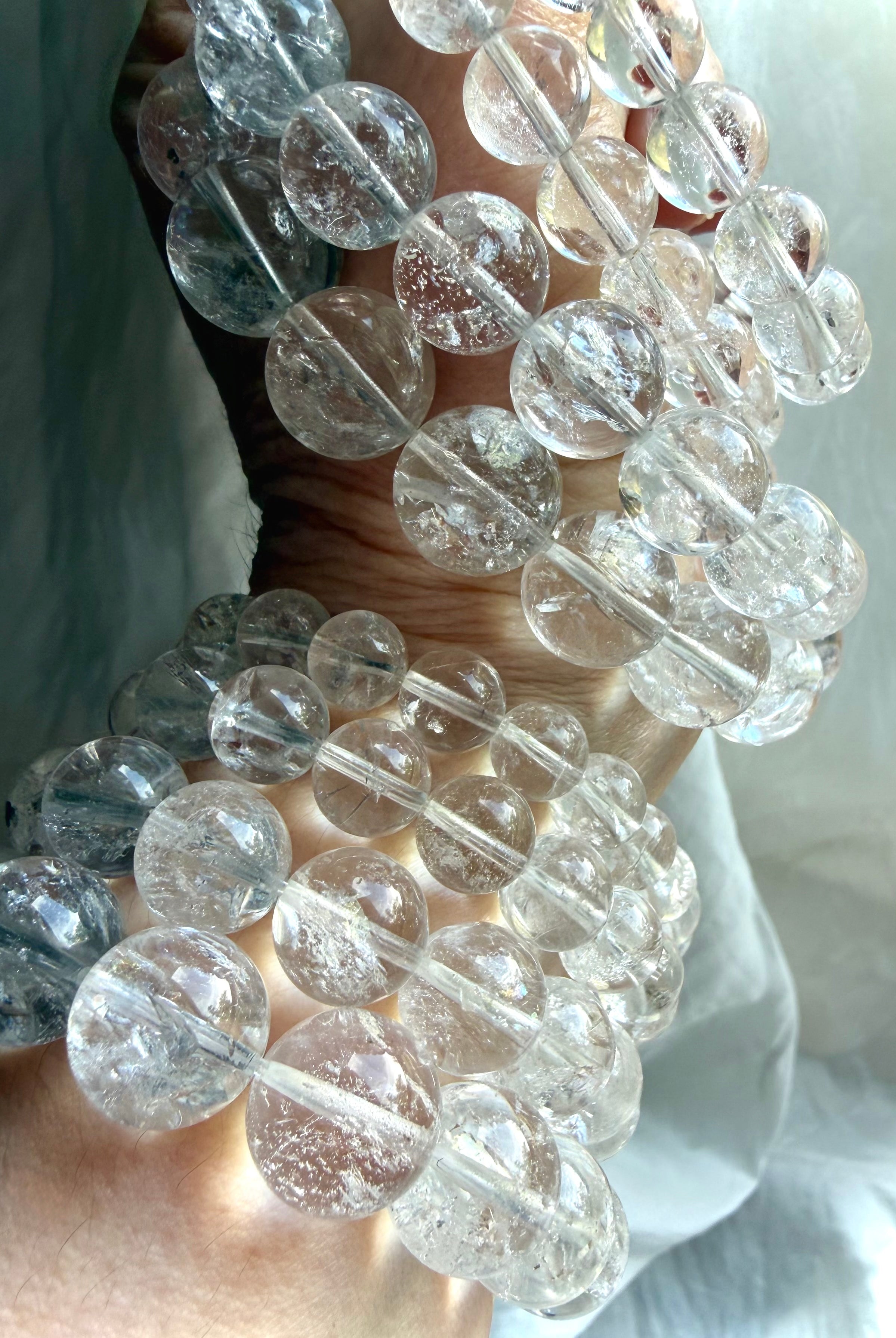 Layered Rainbow Quartz bracelets with glossy polished crystal beads and luxe stacking style