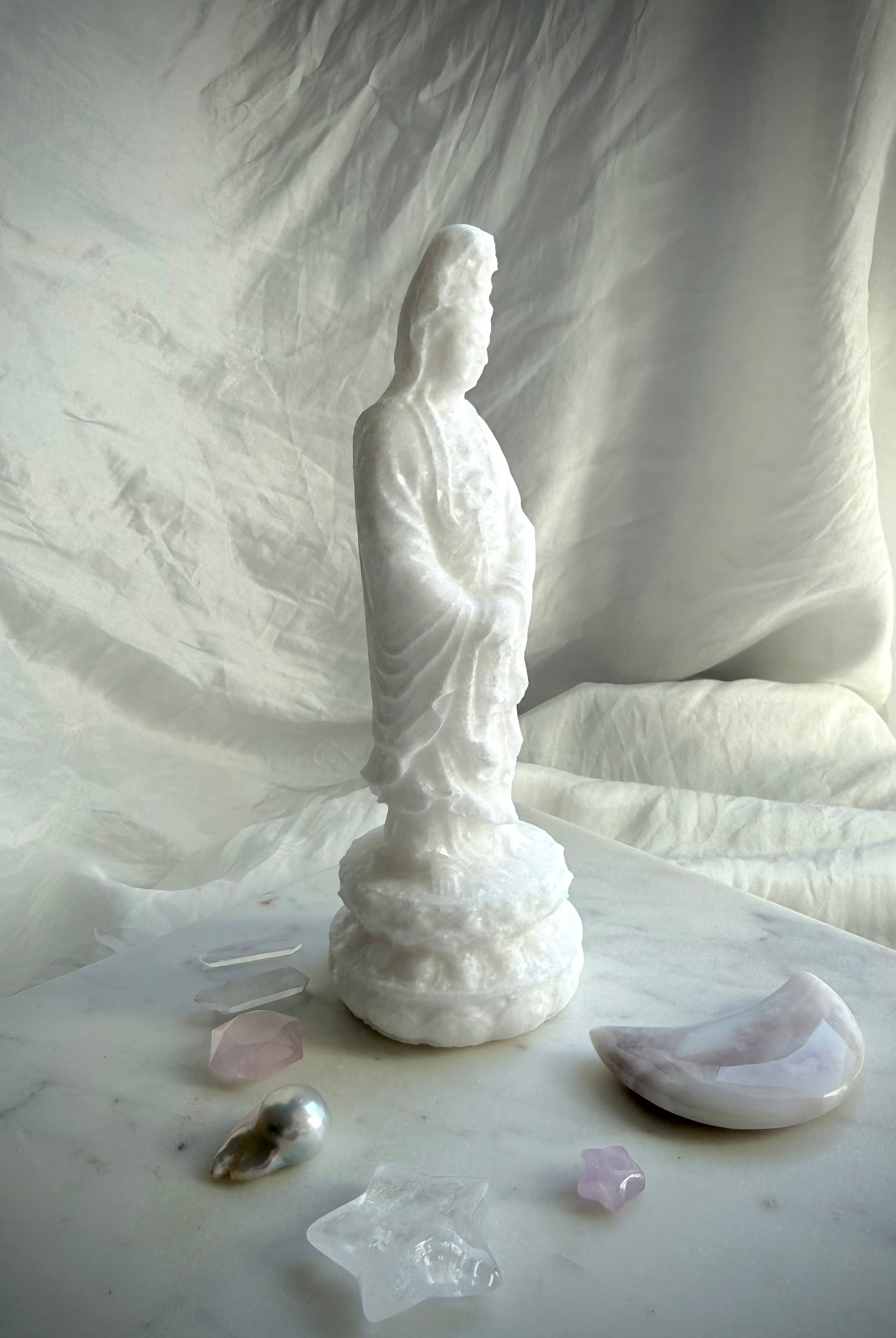 Side view of White Jade Quan Yin carving displaying graceful lines and hand-carved details