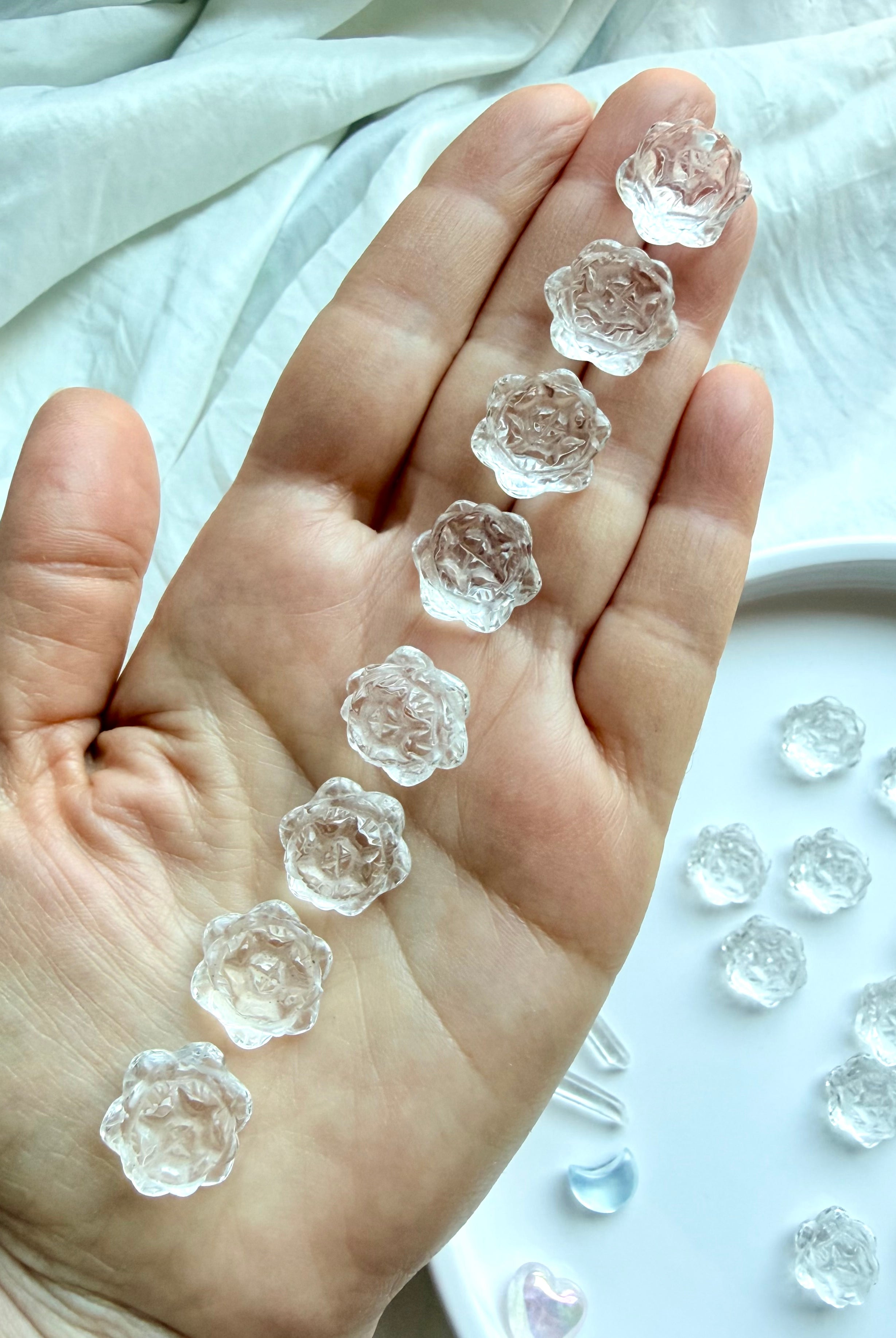 Mini Clear Quartz lotus flower carvings held in hand showing small size and natural crystal clarity