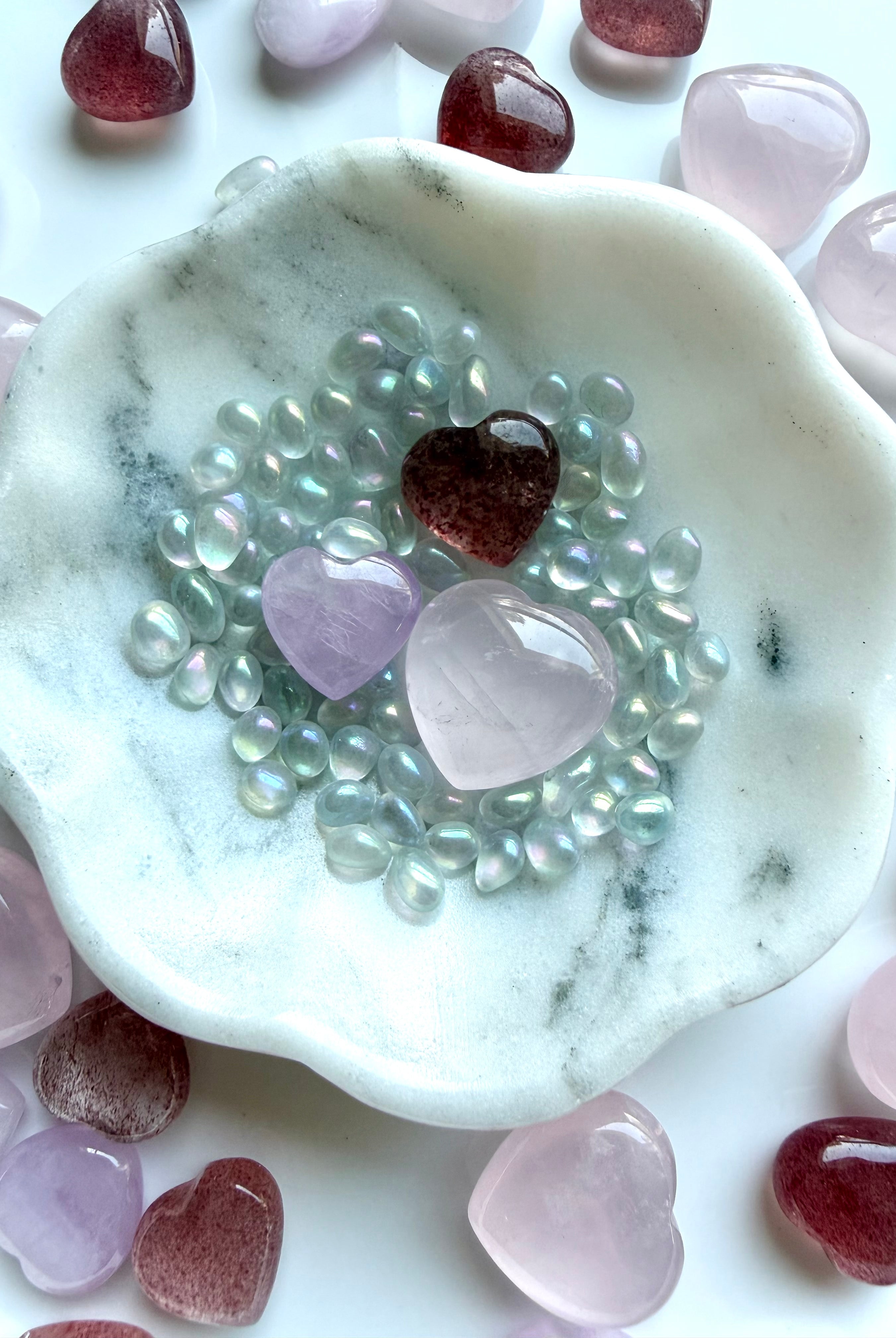 Mini crystal heart set styled in a marble bowl with rose quartz, strawberry quartz, and kunzite for altar decor or gift display