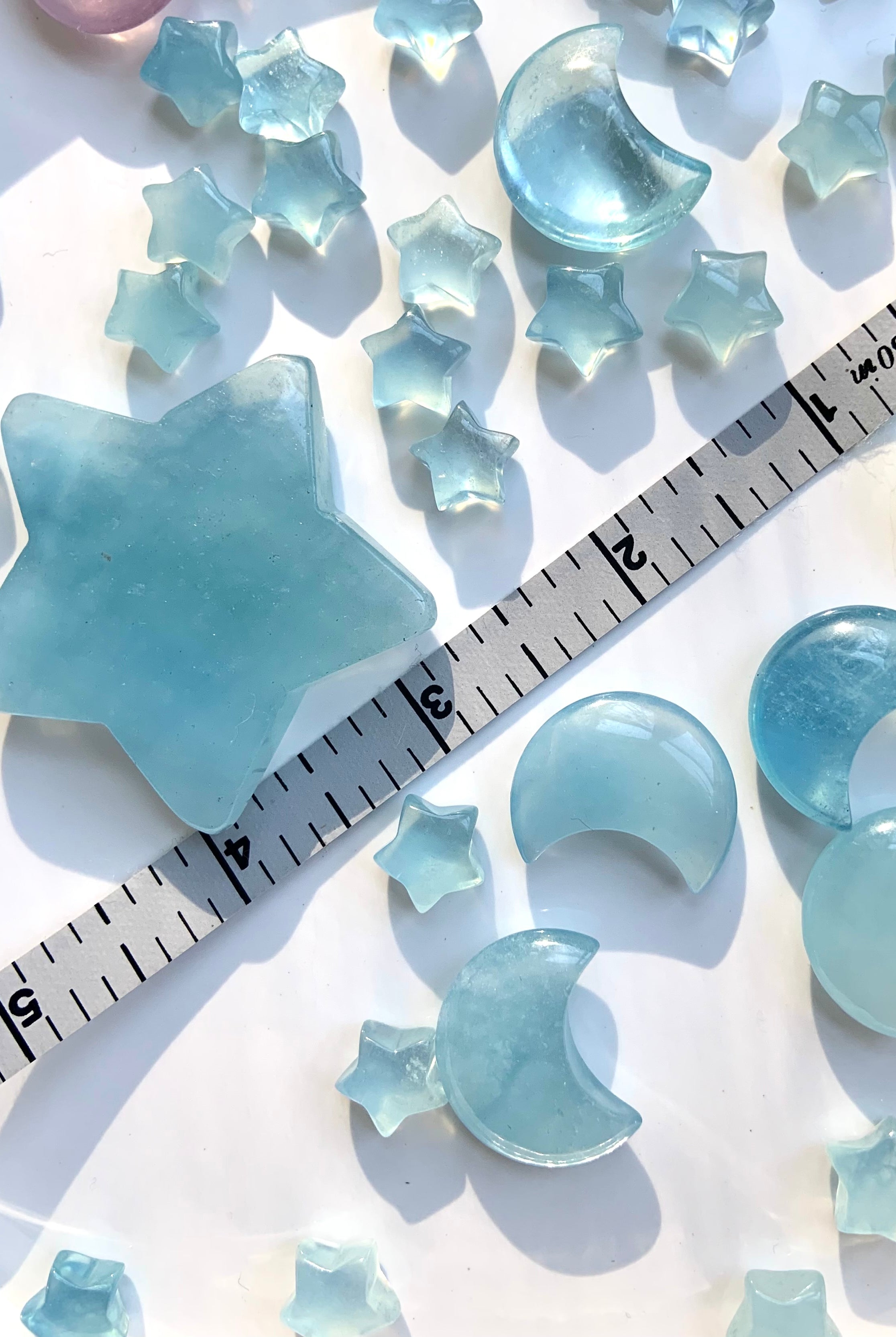 Aquamarine moons and stars with measuring tape for size reference