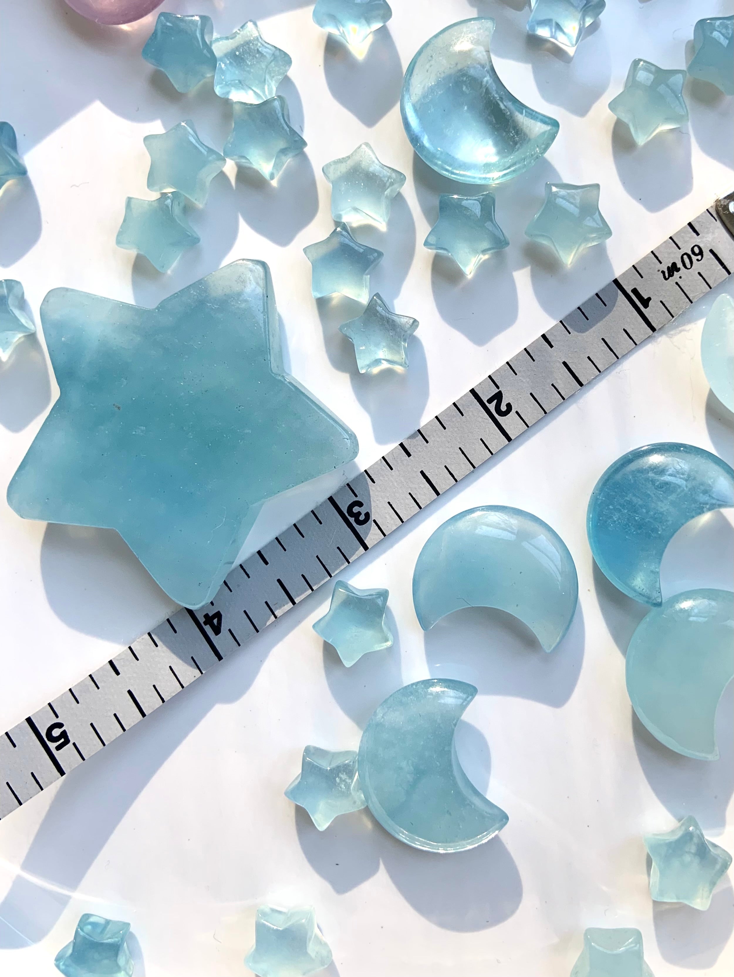 Aquamarine moons and stars with measuring tape for size reference