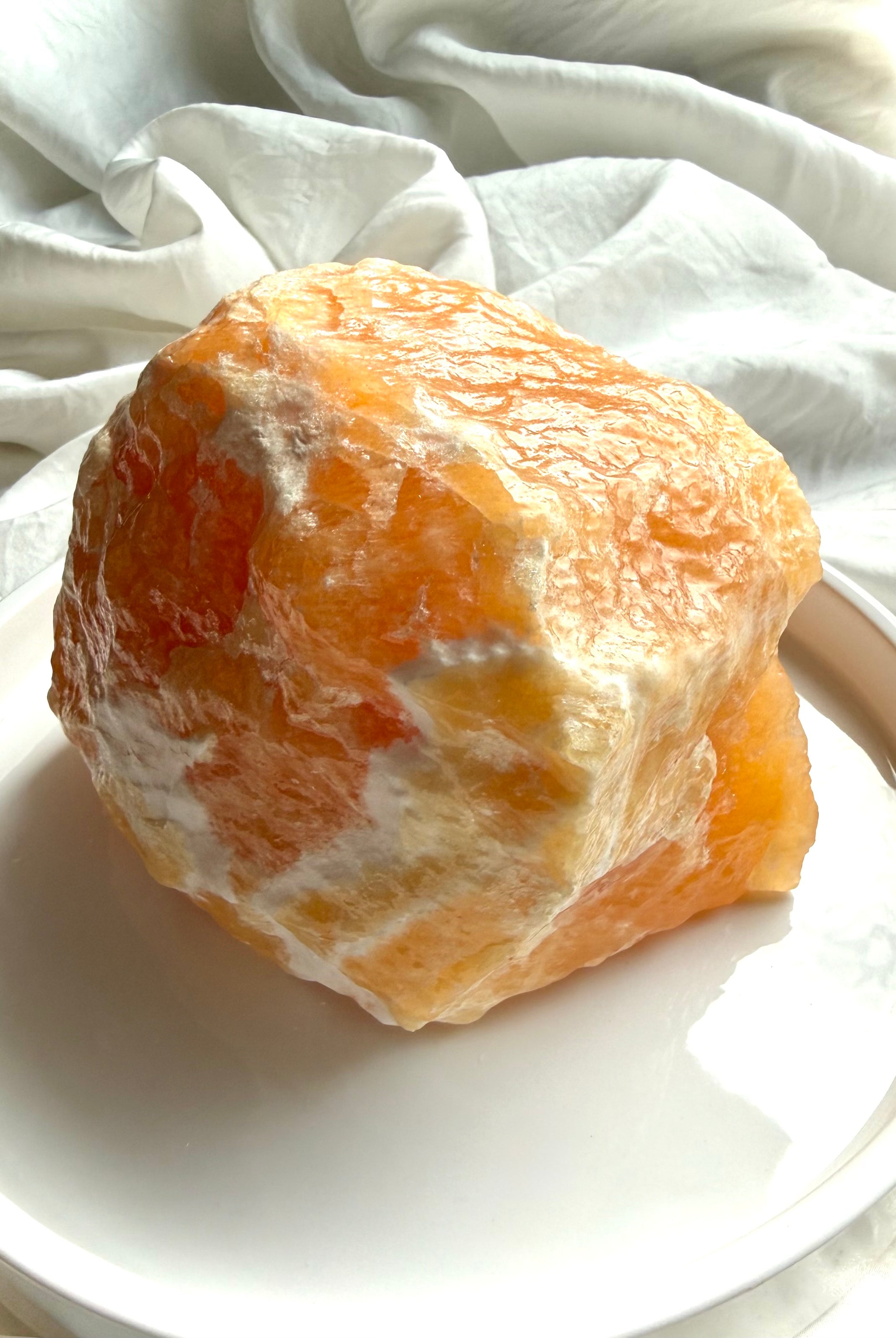 Large Orange Calcite statement crystal with natural texture, translucent edges, and self-standing form