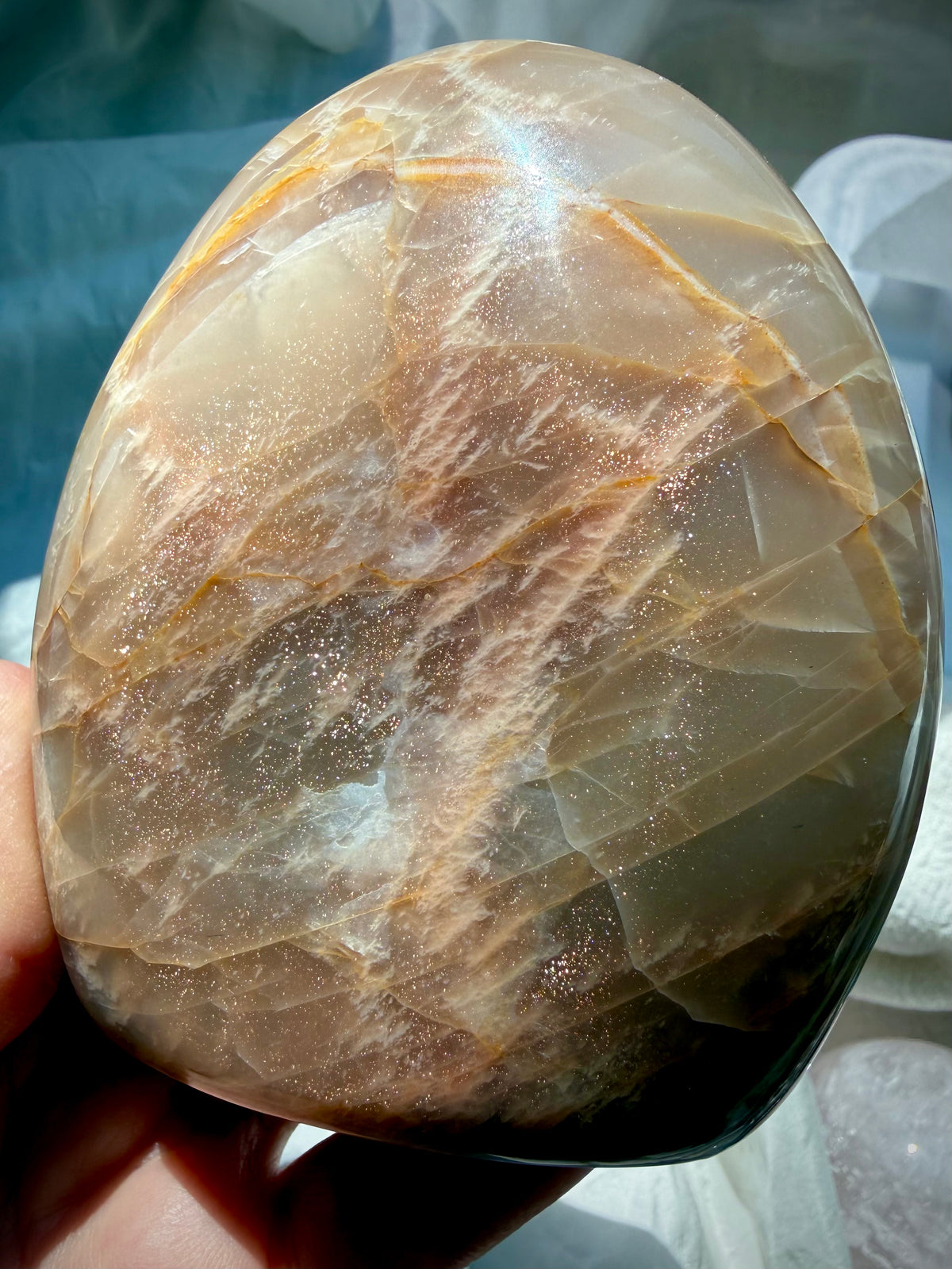 Reverse side of Peach Moonstone freeform with abundant golden Sunstone shimmer sparkling across the polished surface