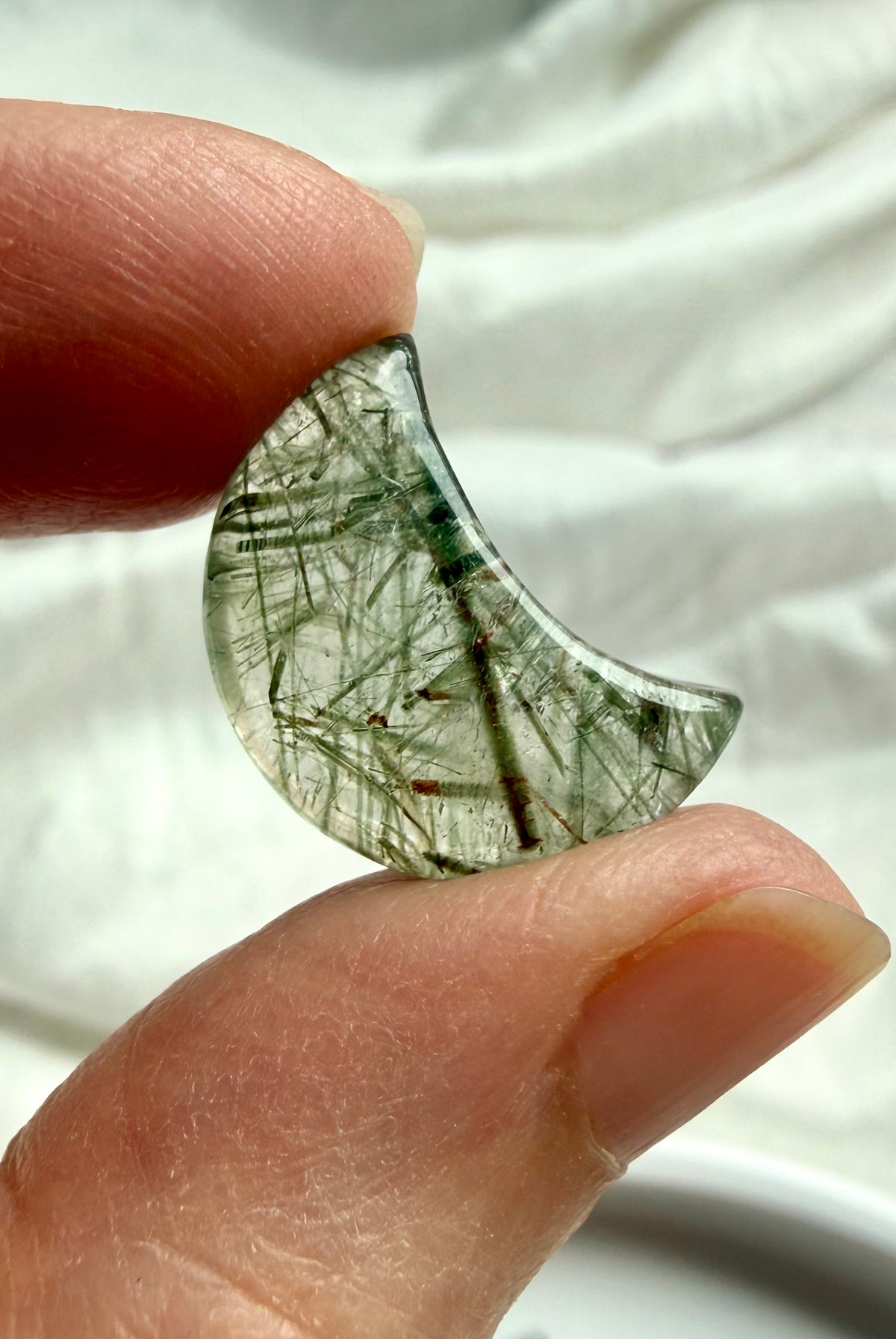 Mini Green Tourmaline Quartz moon held in hand showing translucent crystal and natural green tourmaline inclusions