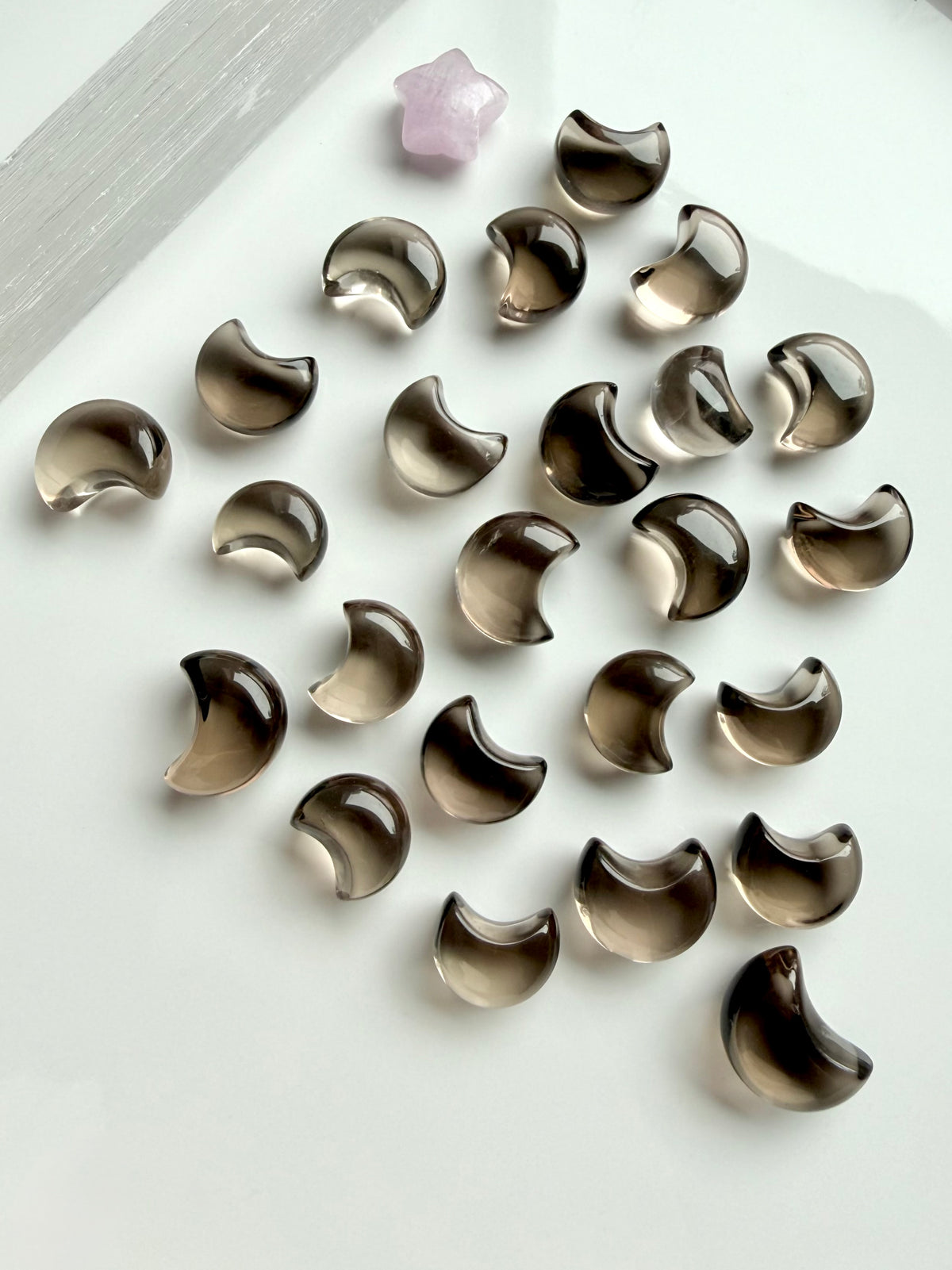 Mini Smoky Quartz moon carvings with translucent smoky brown and champagne tones in a range of tiny crescent moon sizes