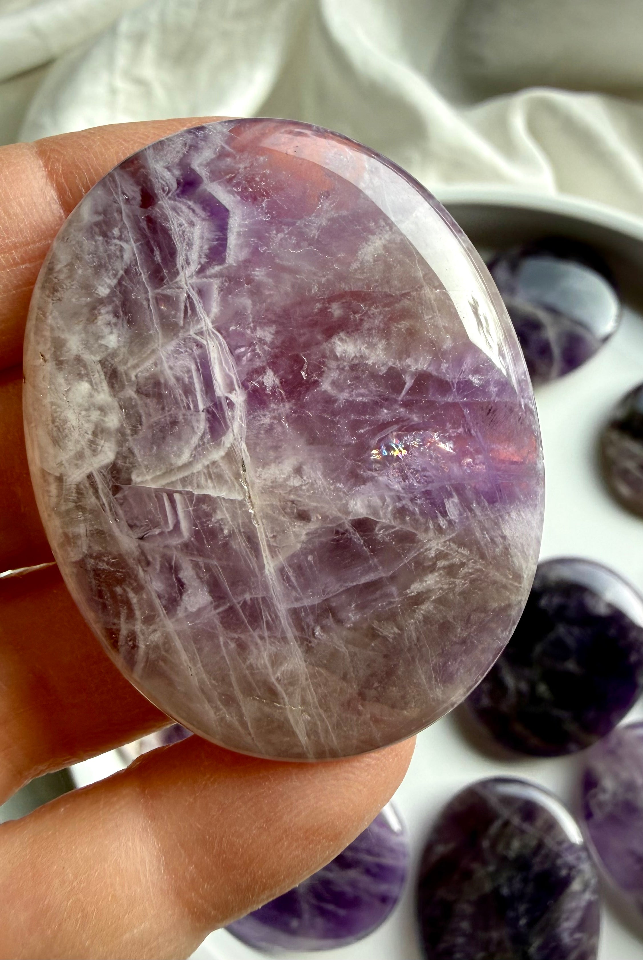 Dream amethyst flat palm stone held in hand, soothing amethyst meditation stone for sleep and relaxation