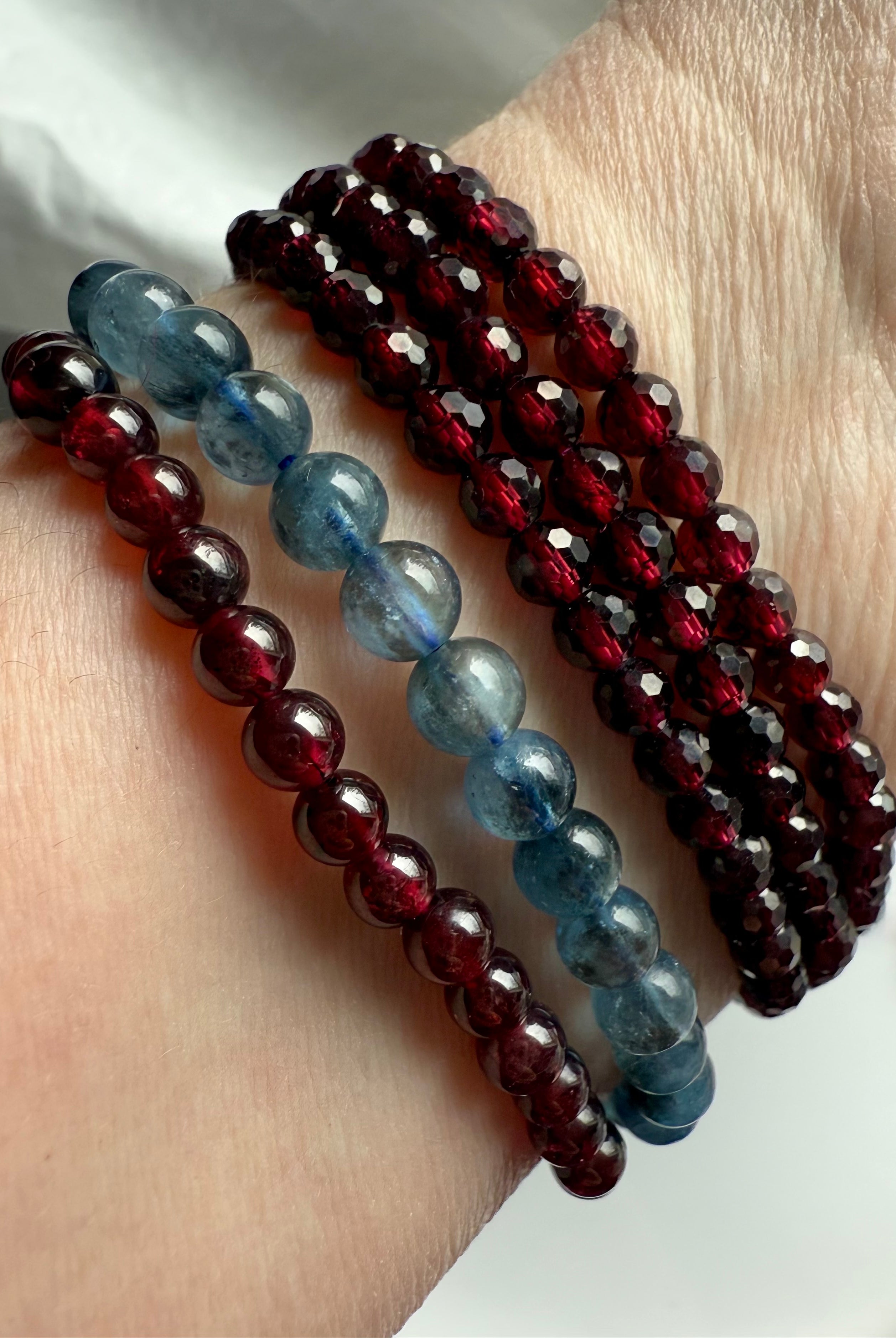 Deep blue Aquamarine Bracelets worn with faceted garnet wrap bracelet + garnet round bead bracelet
