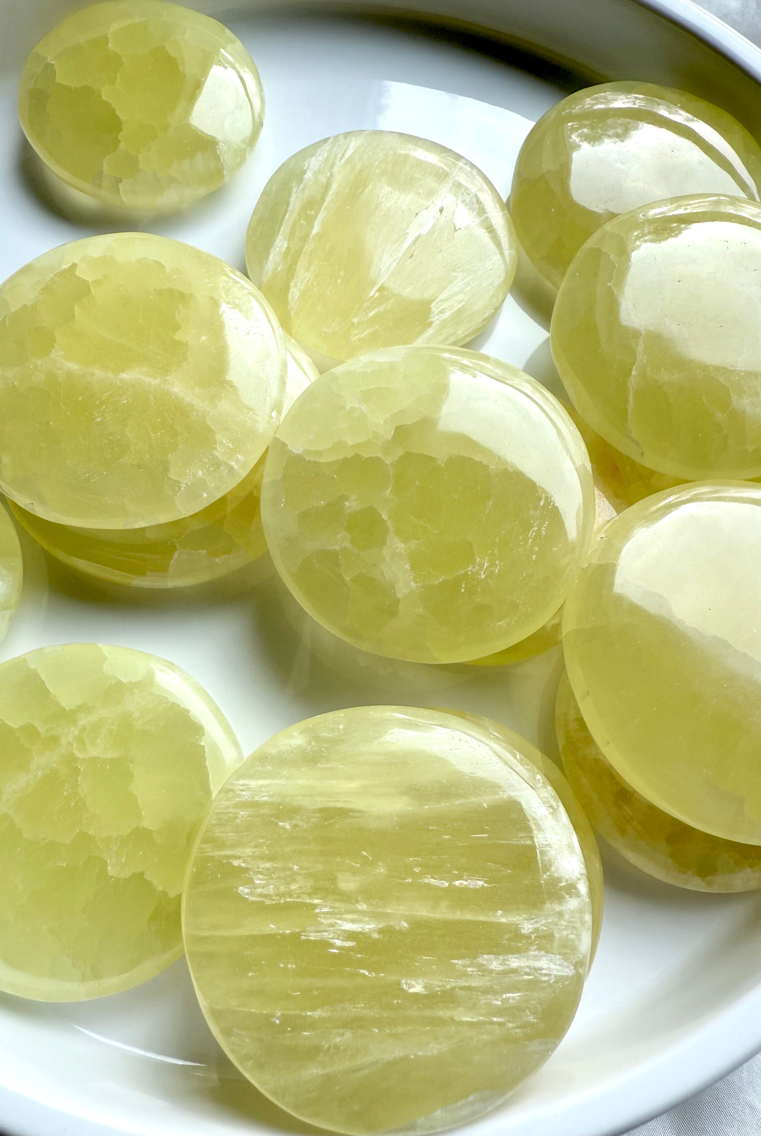 Lemon calcite discs in bright light highlighting natural banding and variation