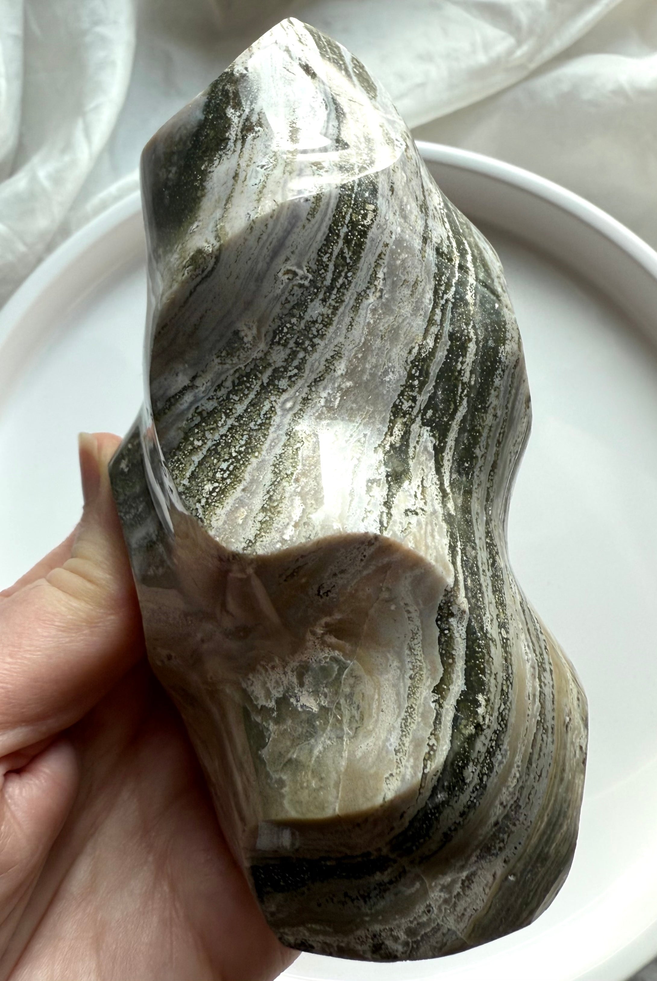 Freeform Green Ocean Jasper carving with swirling green and beige mineral bands, symbolizing divine flow and stability.