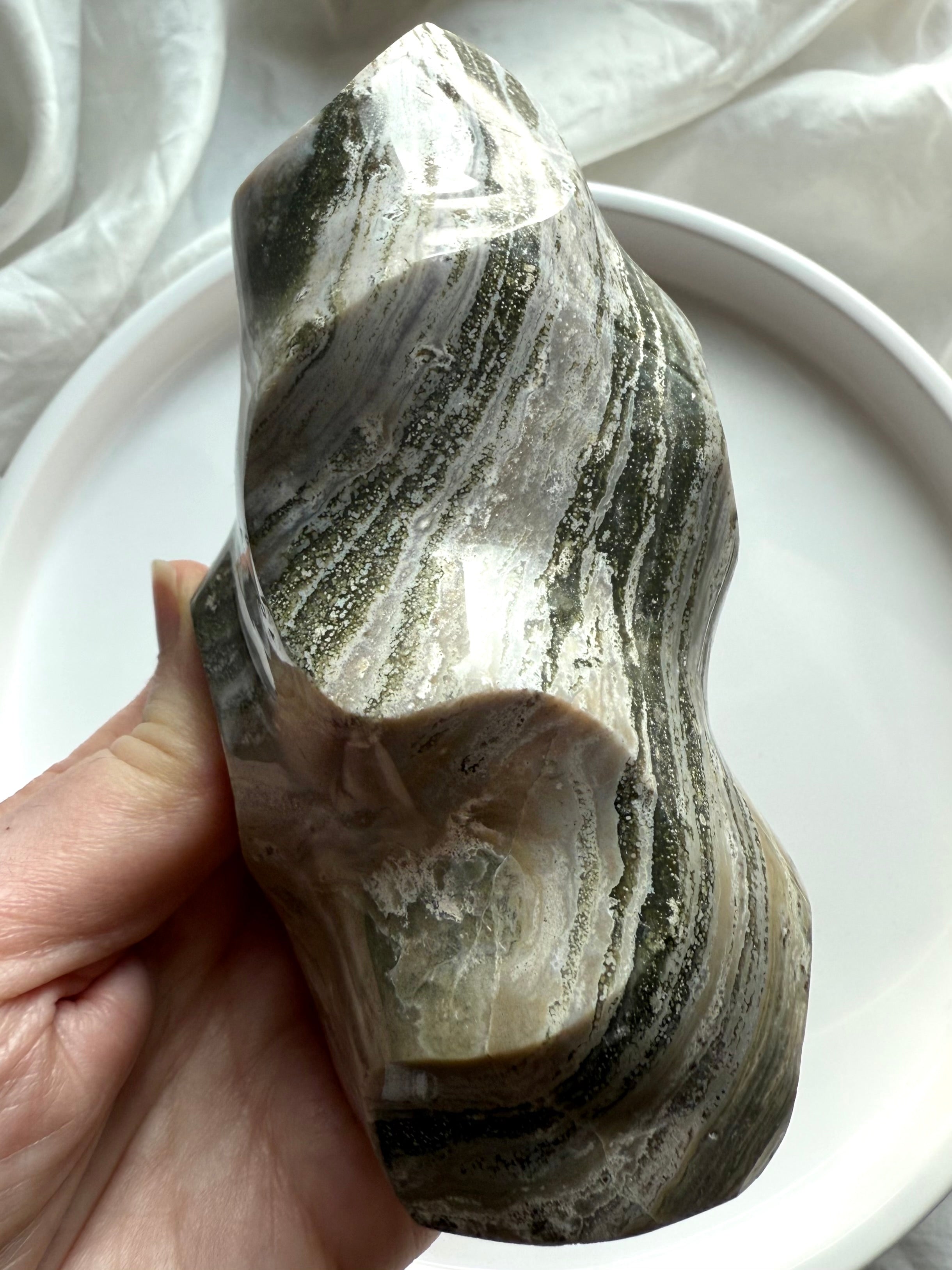 Freeform Green Ocean Jasper carving with swirling green and beige mineral bands, symbolizing divine flow and stability.