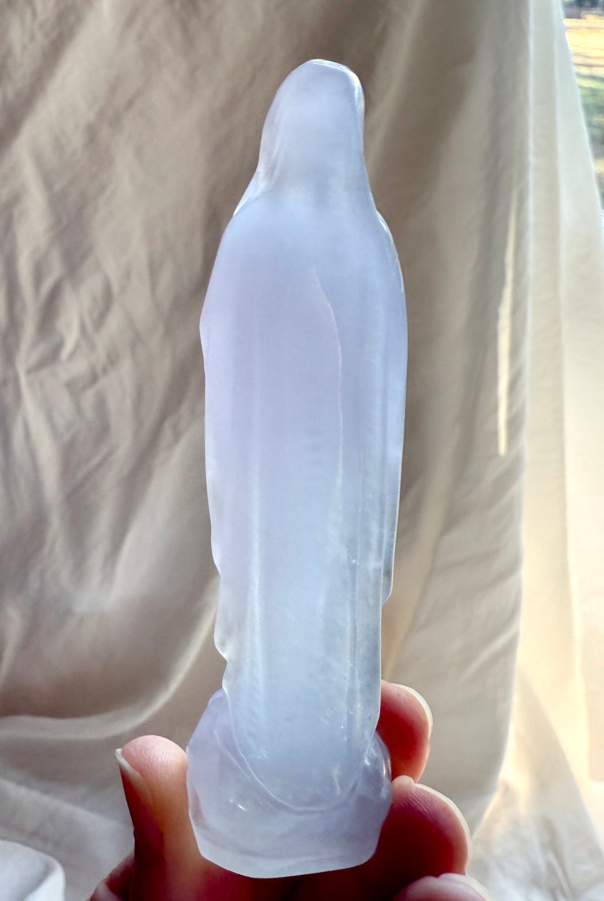 Back view of Lavender Fluorite Mother Mary statue showing flowing carved robes and luminous translucent crystal