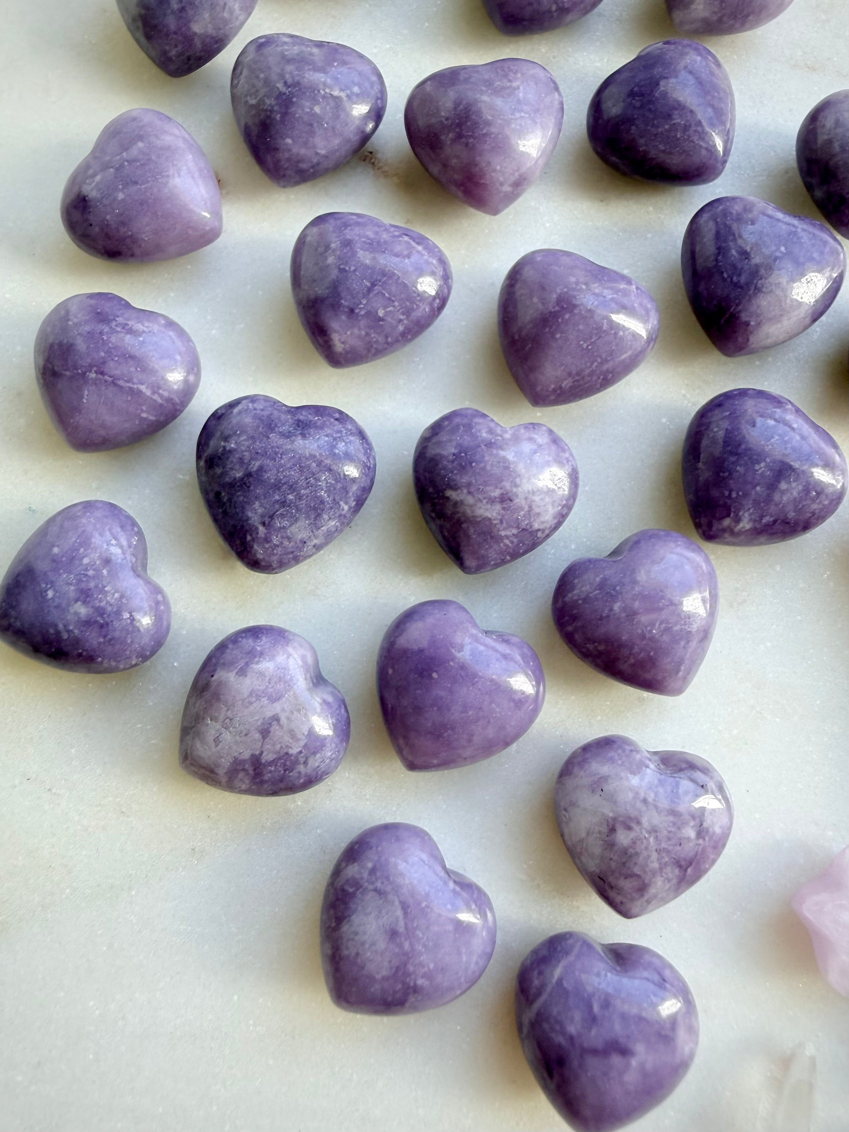 Closeup of Small polished Lilac Lepidolite heart stones with natural lavender marbling