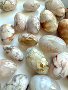 Close up of high quality Flower Agate tumbled stones with beautiful pastel colors on a white plate